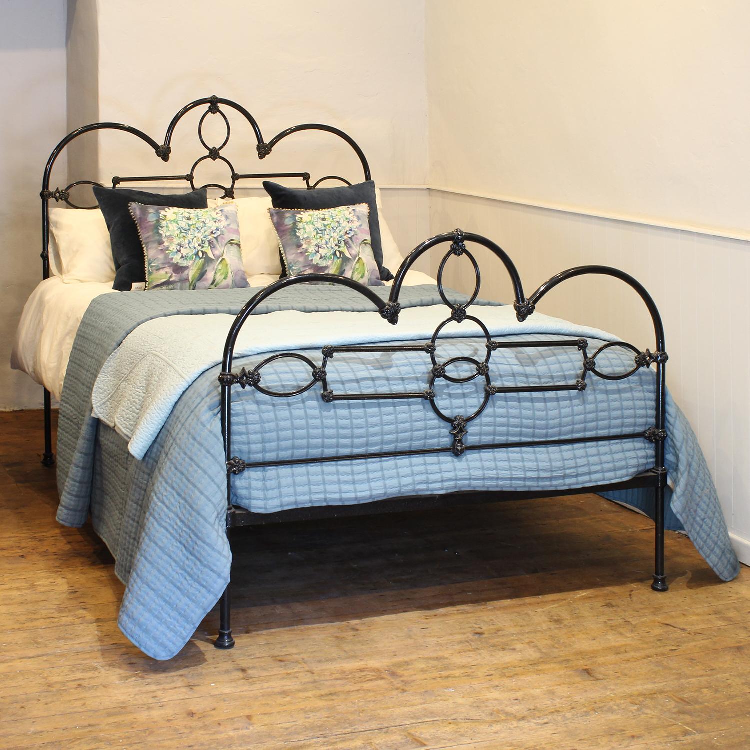 Victorian brass and cast iron bedstead, finished in black with decorative castings and a hoop design.
Some of the castings have faded gold lining highlighting the mouldings.

This bed accepts a double size 4ft 6in wide (54 inch or 135cm) base and