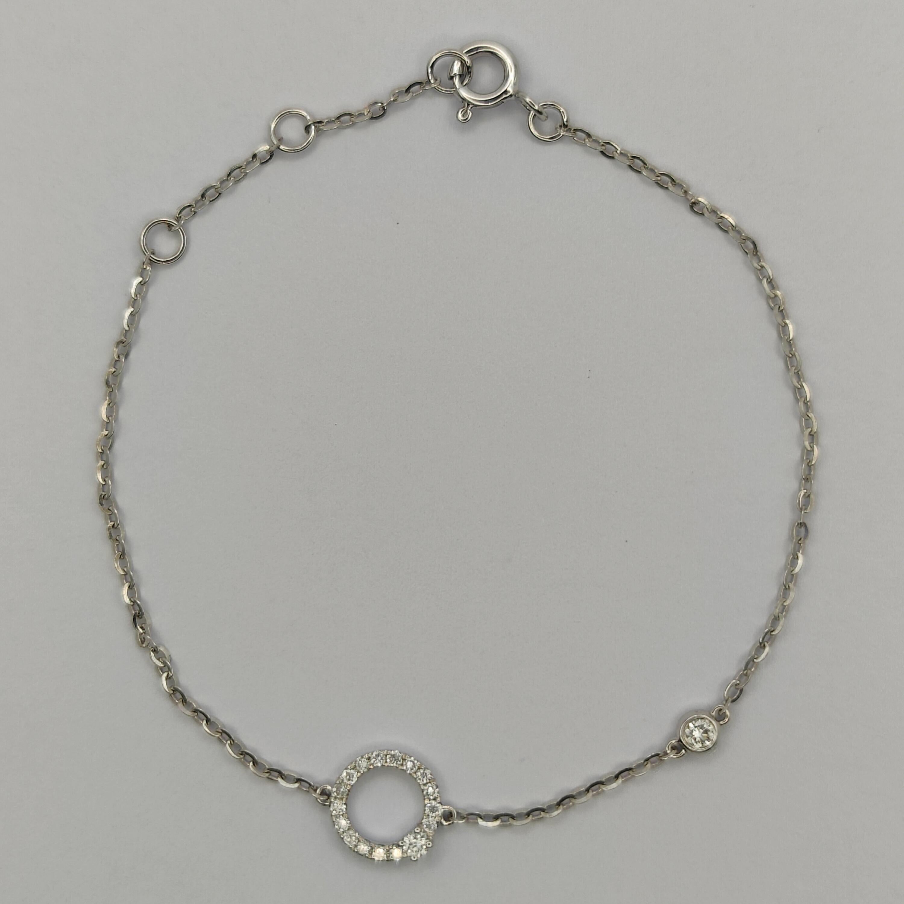 Ce magnifique bracelet en diamants présente un seul cercle de diamants étincelants, avec un diamant autonome plus grand comme pièce centrale. Le bracelet est en or blanc 18 carats, ce qui lui confère un aspect intemporel et élégant. Le pendentif est