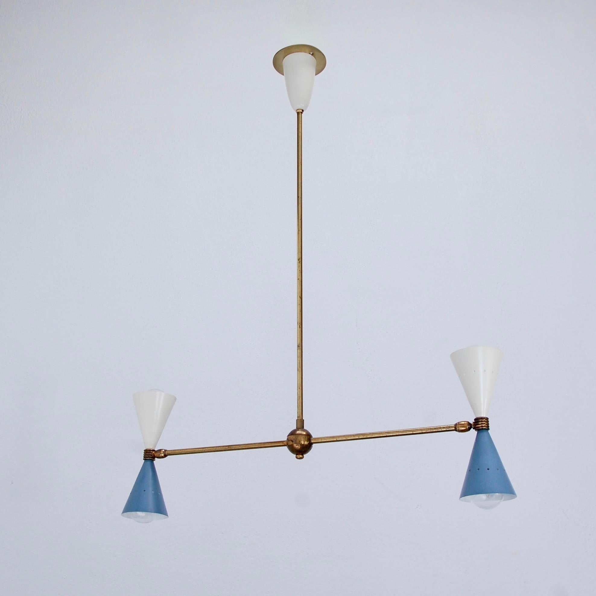 Fine and Minimalist Mid-Century Modern Italian double cone pendant chandelier in original brass finish with painted aluminum up and down cone shade. Partially restored. Rewired with (4) E12 candelabra based light sockets (2) per shade for the US.