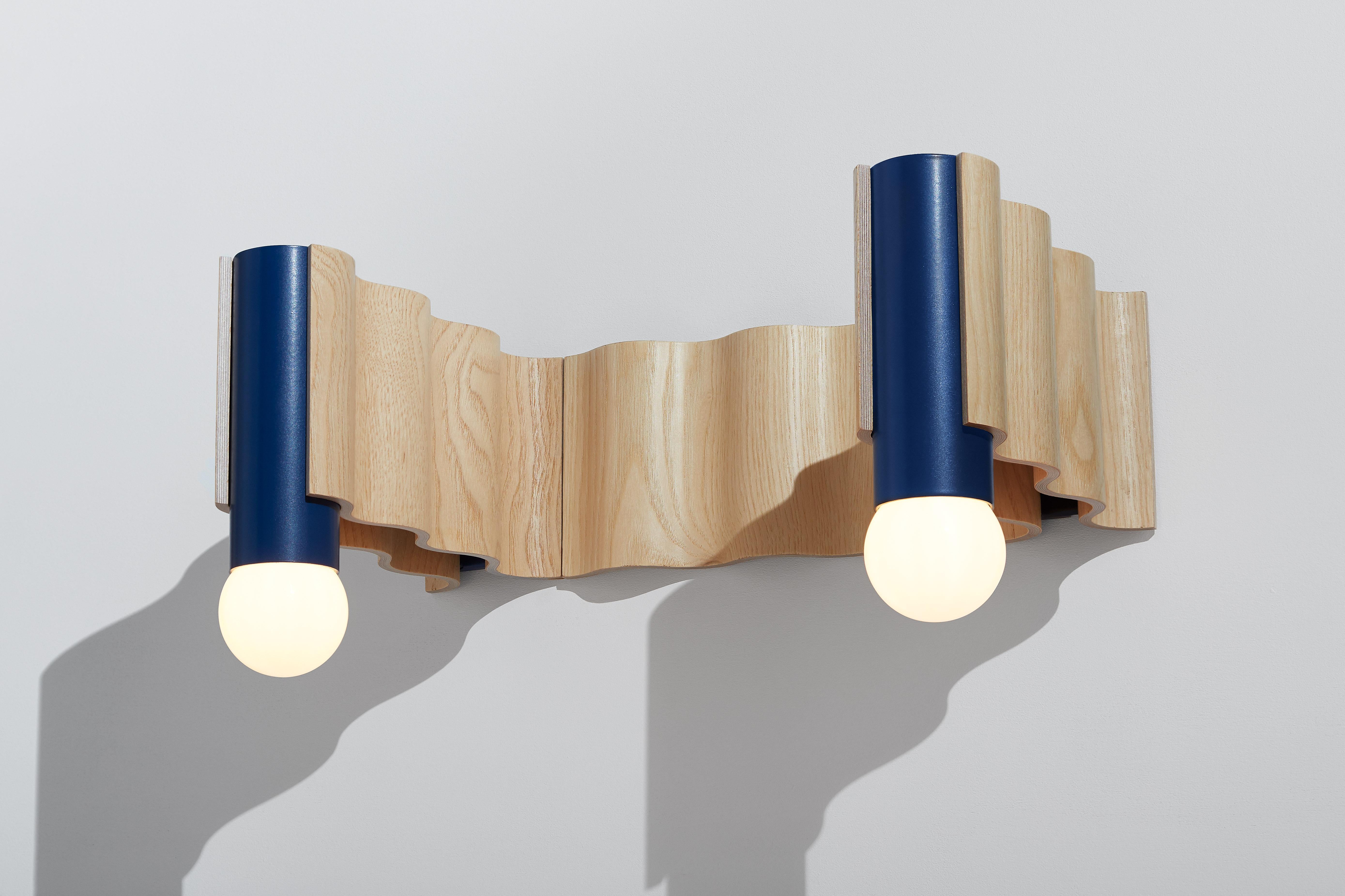 Double sconce made from ash veneered plywood (clear coated) and sapphire blue powder-coated aluminium tube.

Technical information:
- Comes with dimmable bulb (Class A60, 8W, 720 Lumen, 3000° Kelvin, A+ energy rating, Ra > 80)
- Can be wired for a