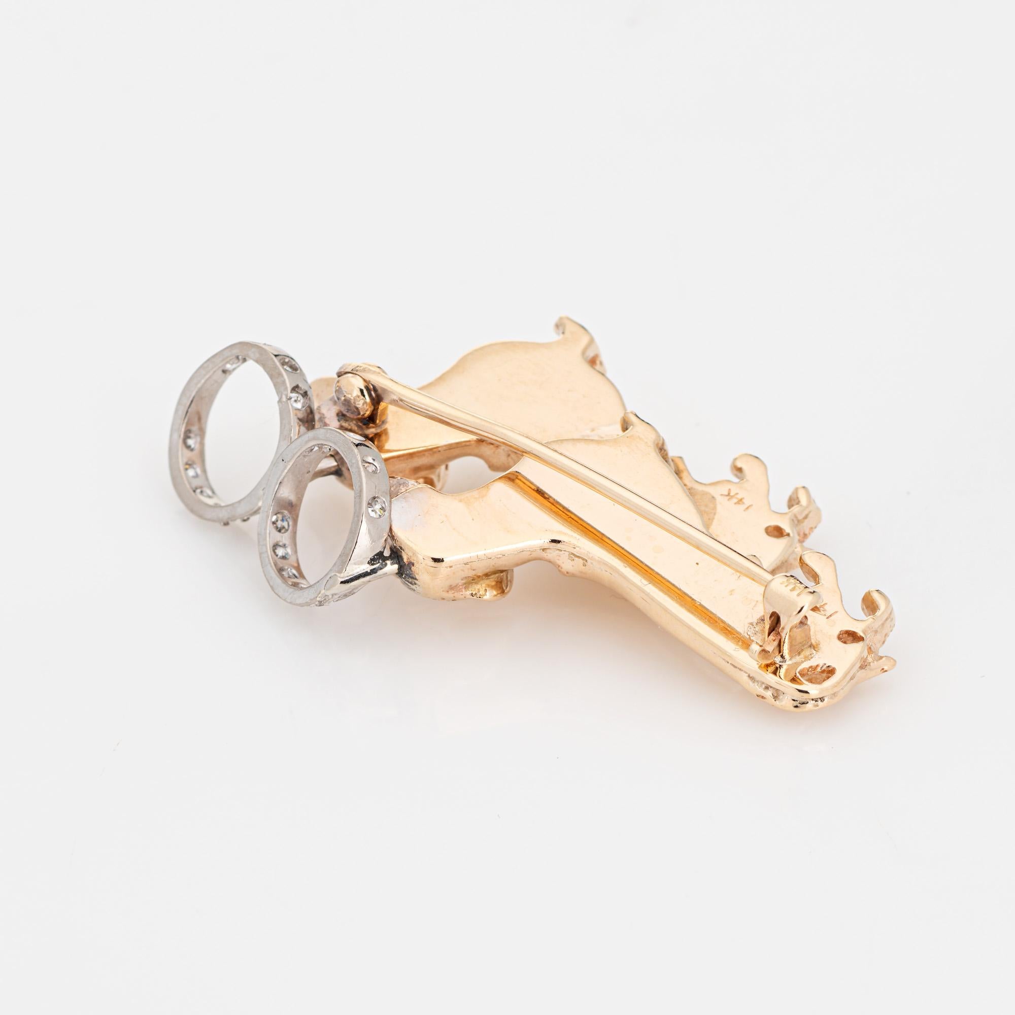 Finely detailed vintage double Dachshund pendant/brooch crafted in 14k yellow gold (circa 1960s to 1970s).  

Diamonds are set into the halos and total an estimated 0.09 carats (estimated at H-I color and VS2-SI2 clarity). Two small approx. 1/2mm