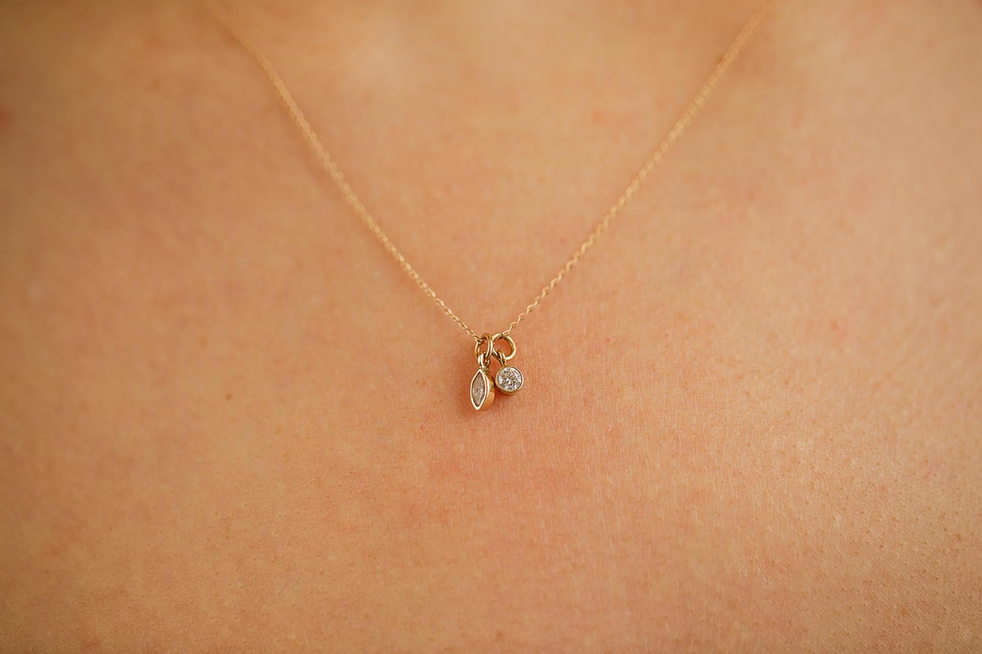 Two diamonds set in an eyeglass bezel setting. One round diamond and one marquise diamond hanging from a delicate curb chain. This 14k solid gold necklace pairs great with the snake chain, and the diamond and sapphire necklaces but can easily be