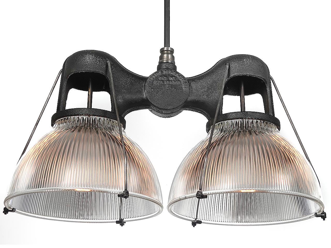 It's getting very hard to find these popular cast double holophanes. They are considered an icon of industrial lighting. It came 2 ways... with 2 matching size domes and with 2 different size domes. This example uses two 12 inch diameter shades of