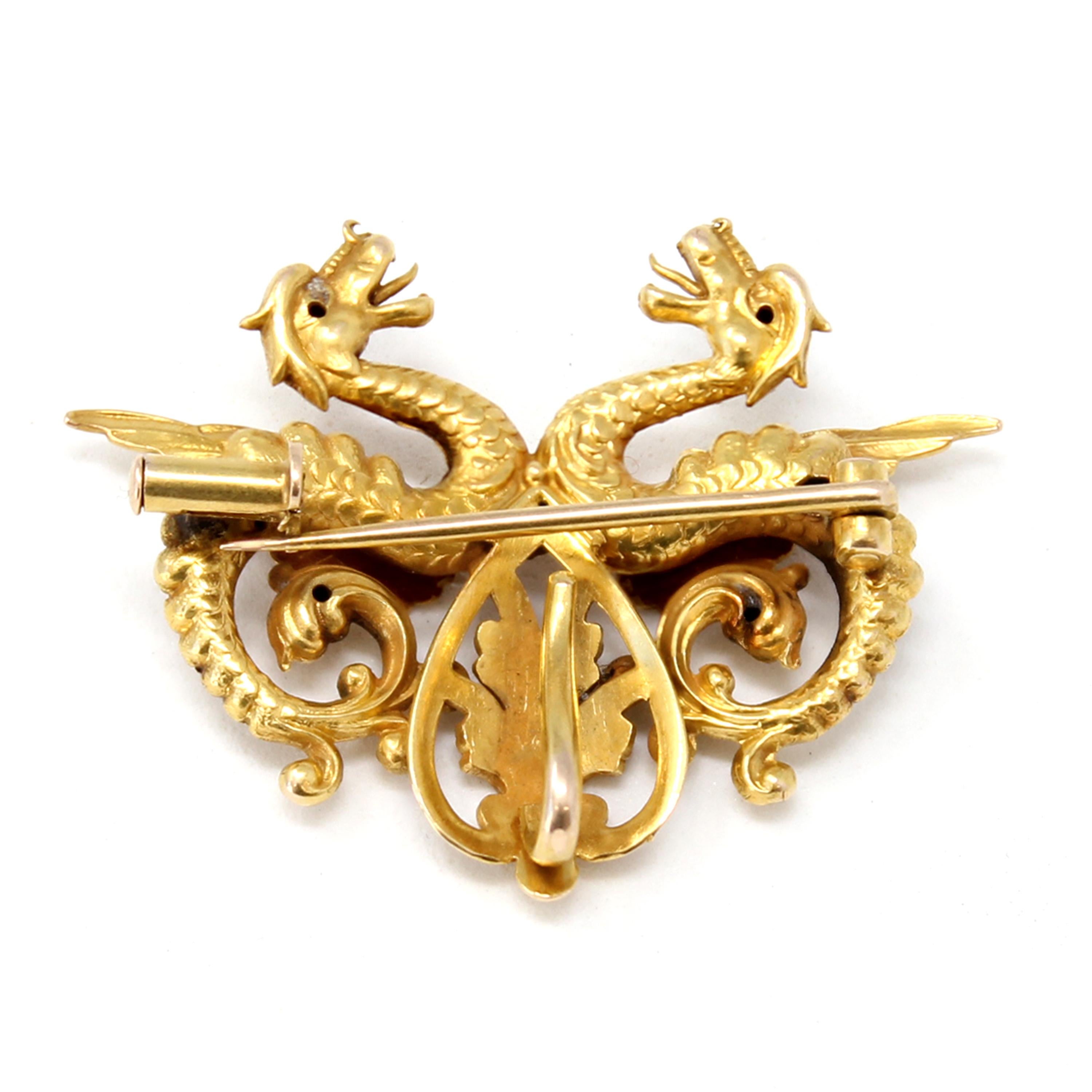 
A brooch converting into a pendant featuring two dragons facing each other set in 14k yellow gold, circa 1940.
