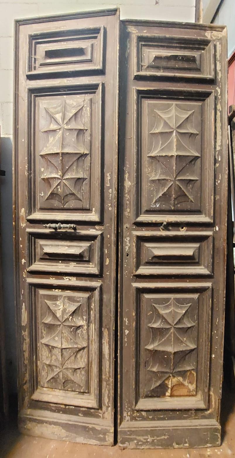 Ancient entrance door, double-leaf main door, richly sculpted with spider web and diamond tiles in solid larch wood, lacquered in imitation walnut, from Turin, late 19th century, maximum size 138 x 268 cm, with rebate approximately 2 cm per side.