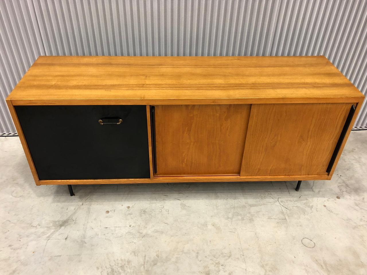 Rare cabinet from the 1950s, veneered on all sides.
Sliding black lacquered doors on one side with shelves, glass shelves on the other side ( one chip on glass )
Two black drop leaf doors opening on a commun space that could be used both sides.