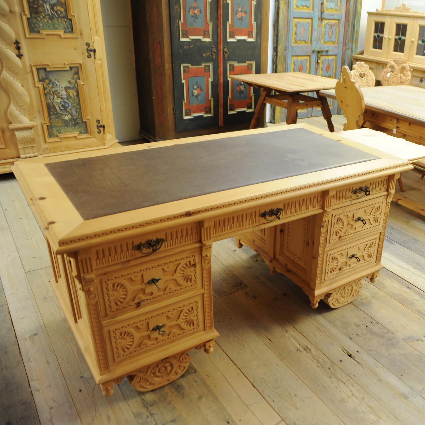 An imposing piece of functional decor that will make a statement in a study or office, this desk can be used on both sides, thanks to the stunning series of bas-relief decorations carved by hand that grace both fronts. Its large size allows it to be