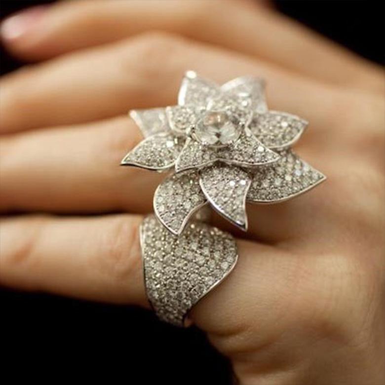Questo squisito anello Flower Power a due dita unisce l'eleganza allo stile moderno, con una serie mozzafiato di 360 diamanti naturali che brillano a ogni movimento. Realizzato in oro bianco 18 carati, il design dell'anello si estende su due dita,