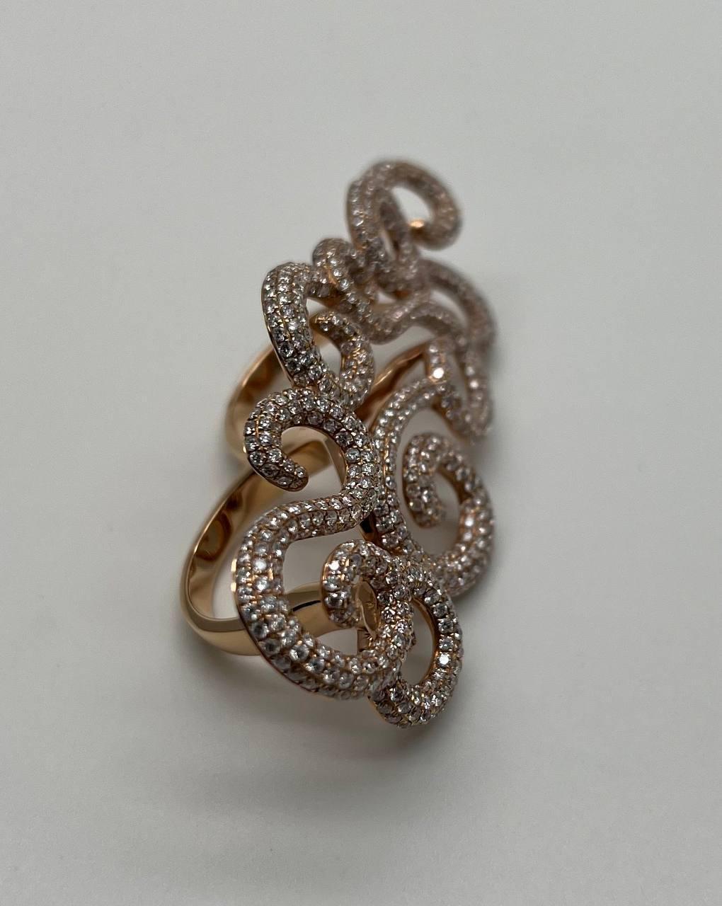 Dieser Ring zeichnet sich durch verschlungene, wirbelnde Muster aus, die mit funkelnden Diamanten von 4,90 ctw besetzt sind und einen faszinierenden visuellen Effekt erzeugen.

Das elegante Design zeigt eine harmonische Mischung aus Kurven und