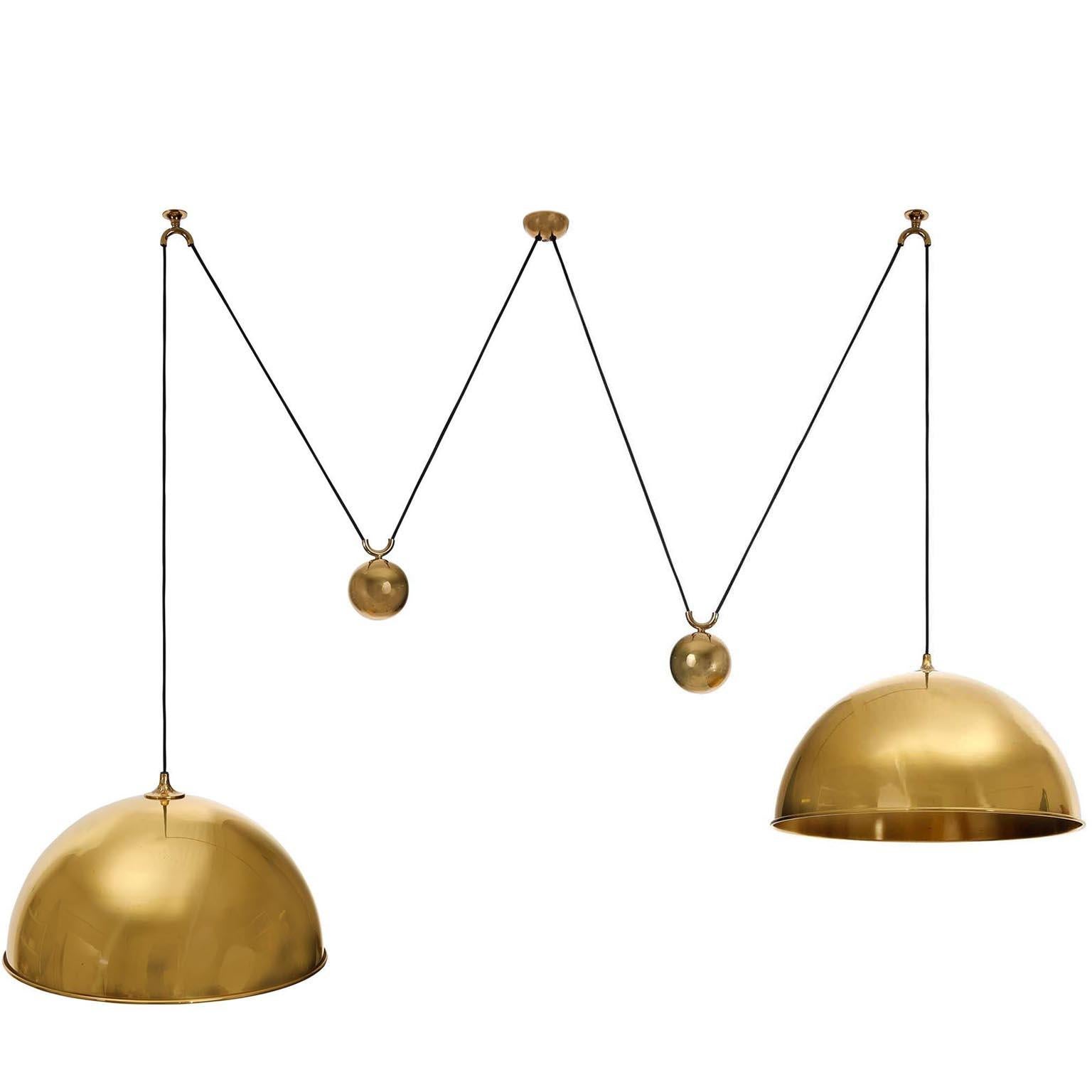A height adjustable pendant lamp by Florian Schulz, Germany, manufactured in midcentury, circa 1970 (late 1960s-early 1970s).
All parts are made of solid polished brass which have an aged surface in a rich and warm tone and lovely patina.
The