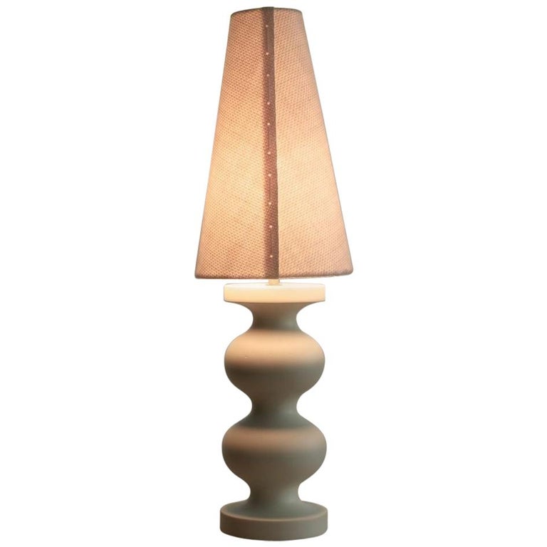 
This sculptural Italian linen and solid timber table lamp is an artisanal, hand-made timeless example of 21st century organic modern design, reminiscent of Brancusi and Arp, minimal, totemic 20th century sculptors crossed with a light-hearted