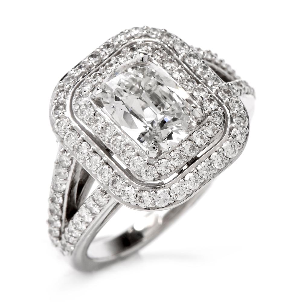 This stunning diamond engagement ring is crafted in solid platinum. Displaying a prominent four prong set cushion cut GIA certified diamond approx. 1.42 CT, J color, I1 clarity. Surrounded by a double halo and split shank of pave set small round