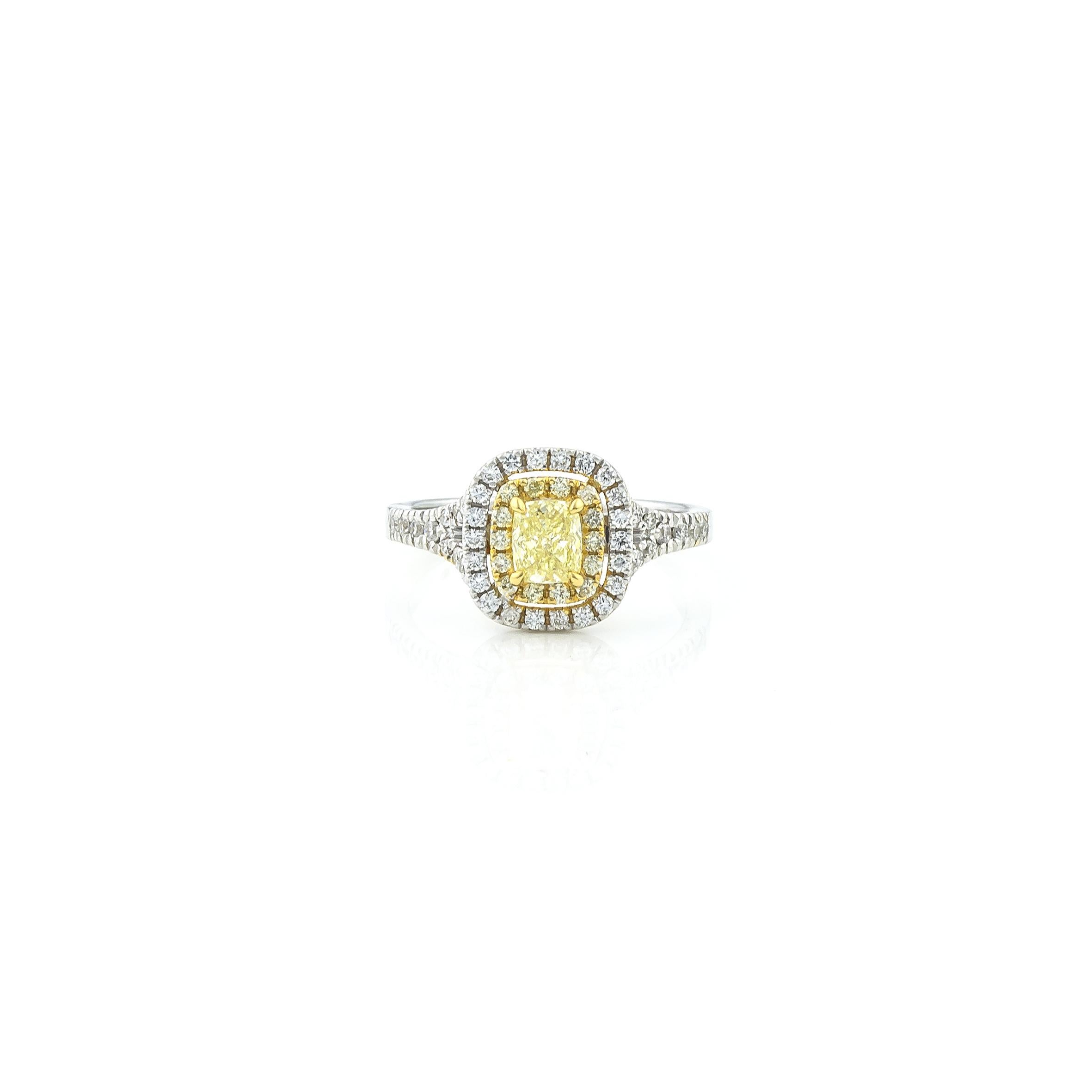 Double Halo Cushion Yellow Diamond Ring 0.66 carat, in 18KT White Gold, surrounded by 0.54 carat white brilliant cut diamonds Pave Set Sholders.
The two Haloes of Pave diamonds reflect the light while the central yellow diamond, set among with four