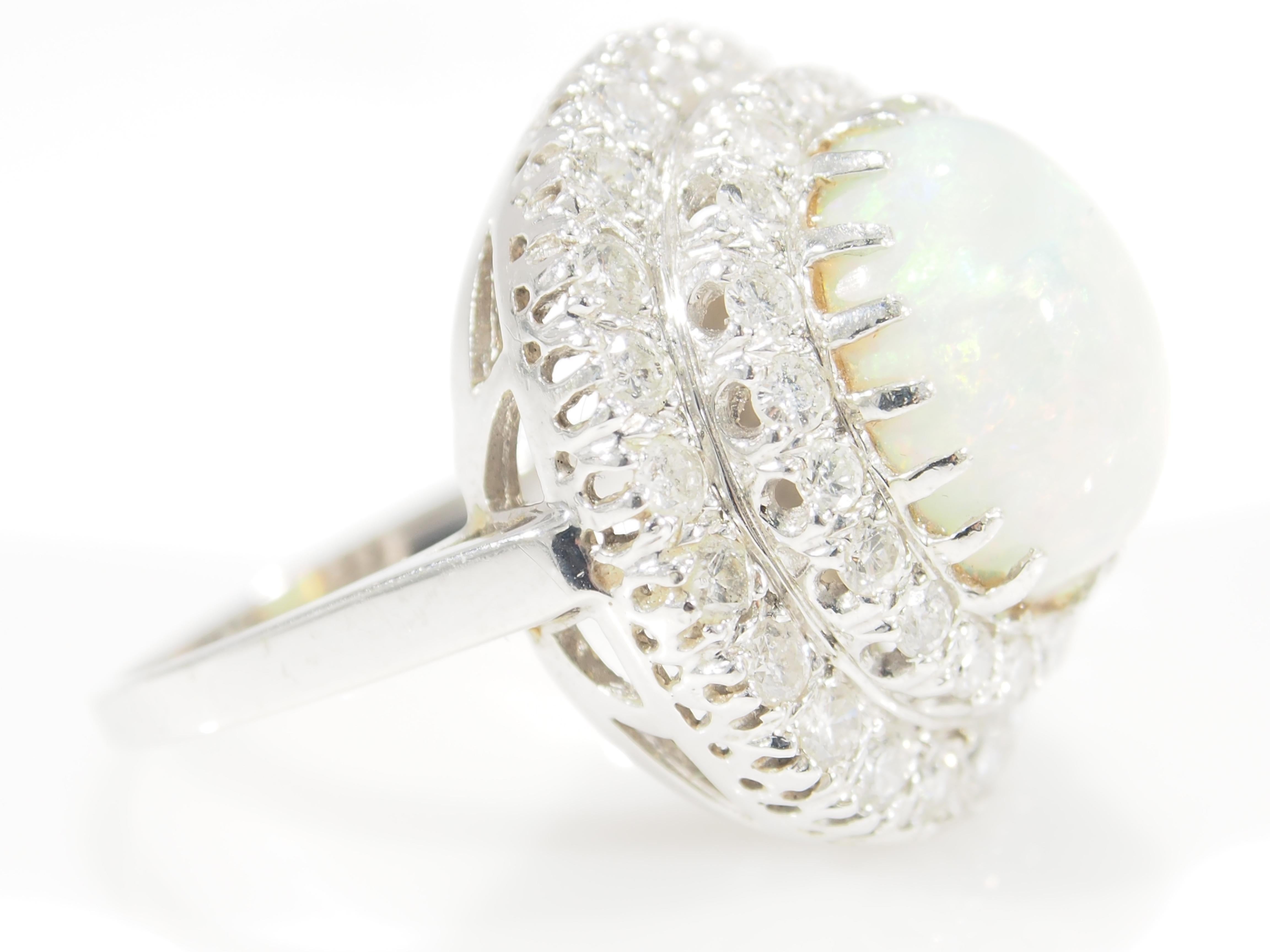 This is a classic Cabochon Opal Ring designed in 14K White Gold set in a Double Halo. The Opal is 4.57ctw. and is surrounded by (42) Round Brilliant Cut Diamonds, approximately 1.33ctw, H-K in Color, VS-I1 in Clarity. This splendid Ring is 3/4 inch