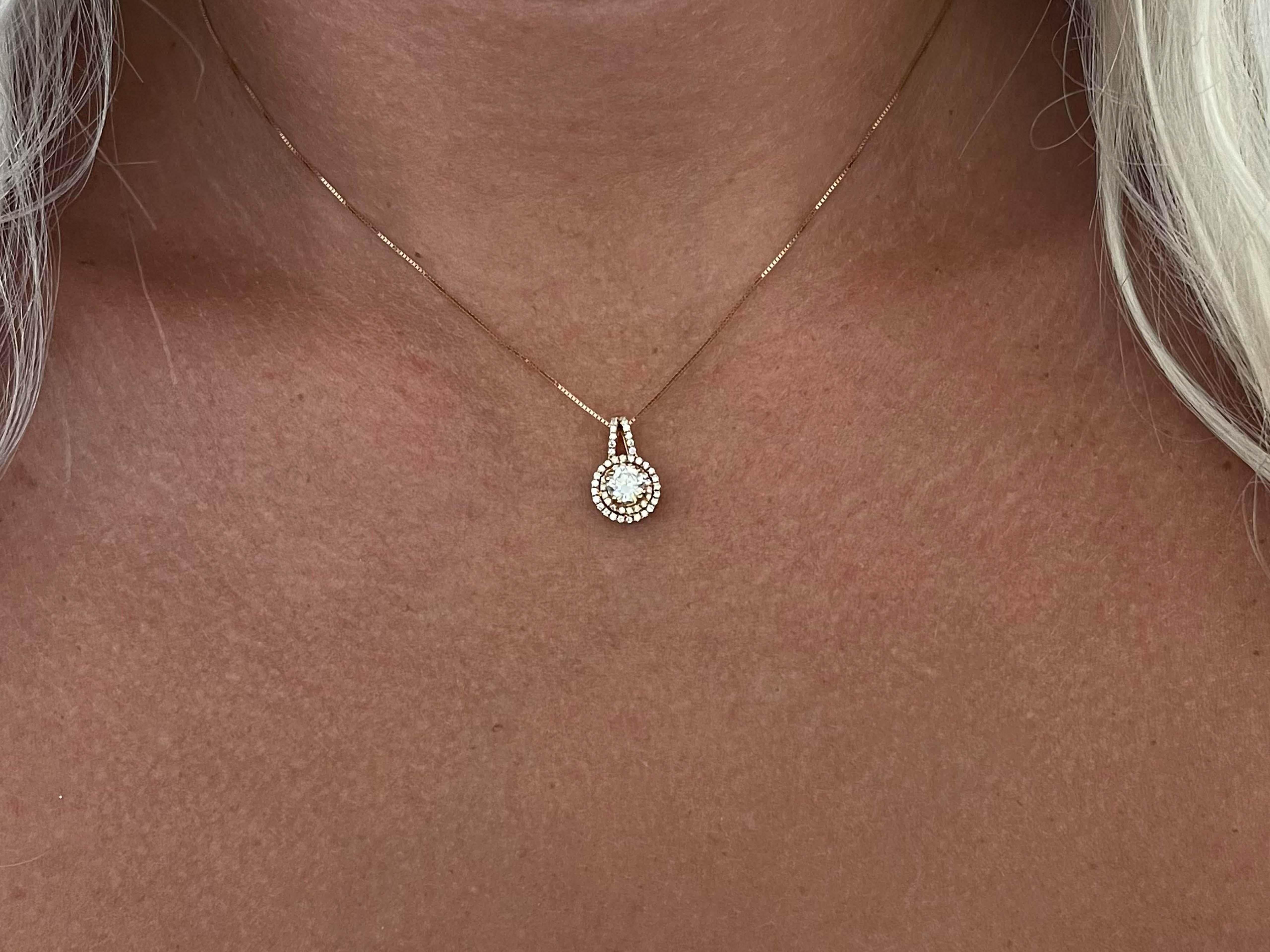 The center diamond is H in color and SI2 in clarity and weighs 0.52 carats. The pendant features an additional 54 round brilliant diamonds, G in color and VS in clarity, weighing 0.26 carats. Altogether the diamond weight is 0.78 carats. The pendant