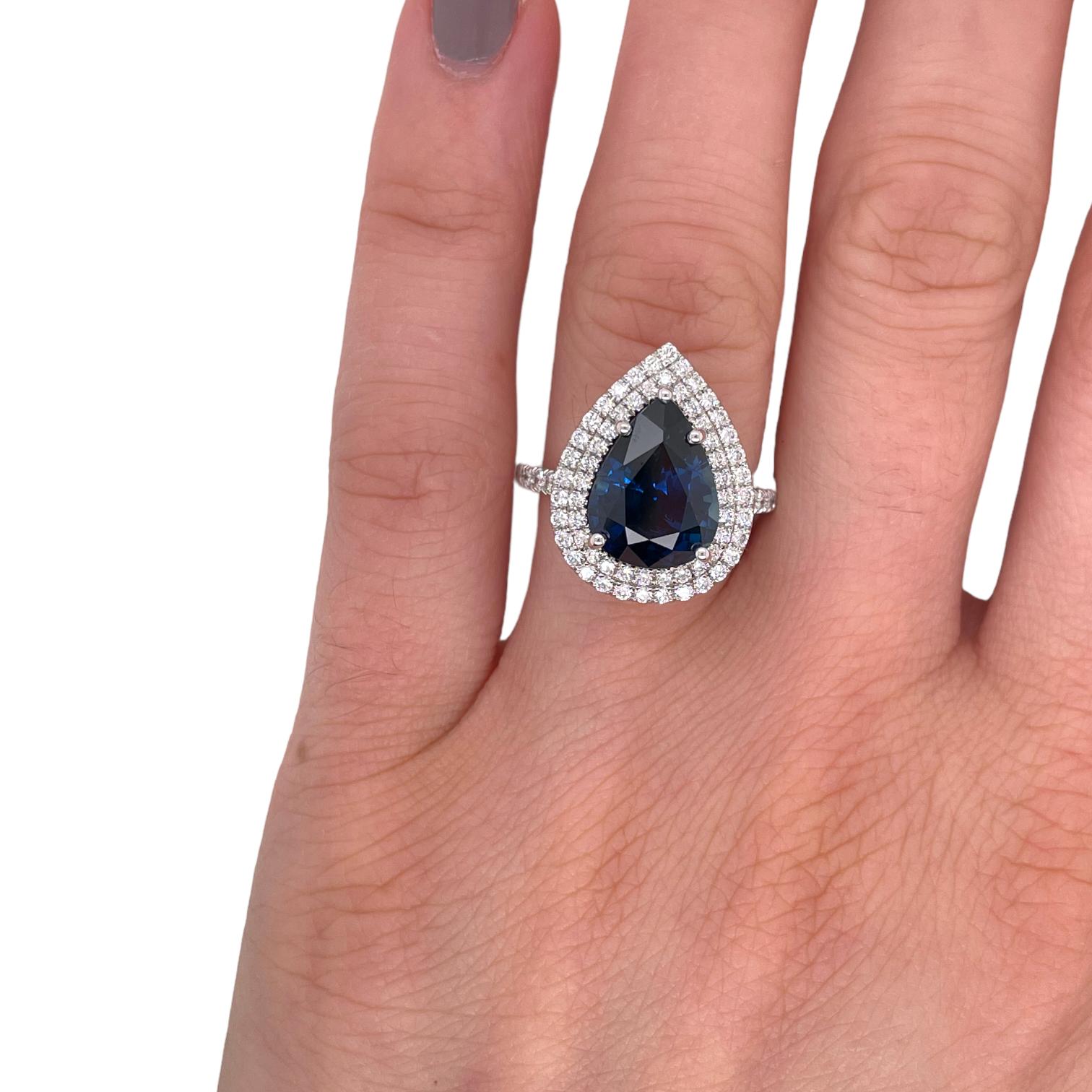 Ring contains one GIA certified pear shape sapphire 5.81ct and round brilliant diamonds surrounding 0.73tcw. Sapphire and diamonds are mounted in a handmade basket prong setting. Diamonds are F in color and VS2 in clarity. Ring is a size 6.25 and