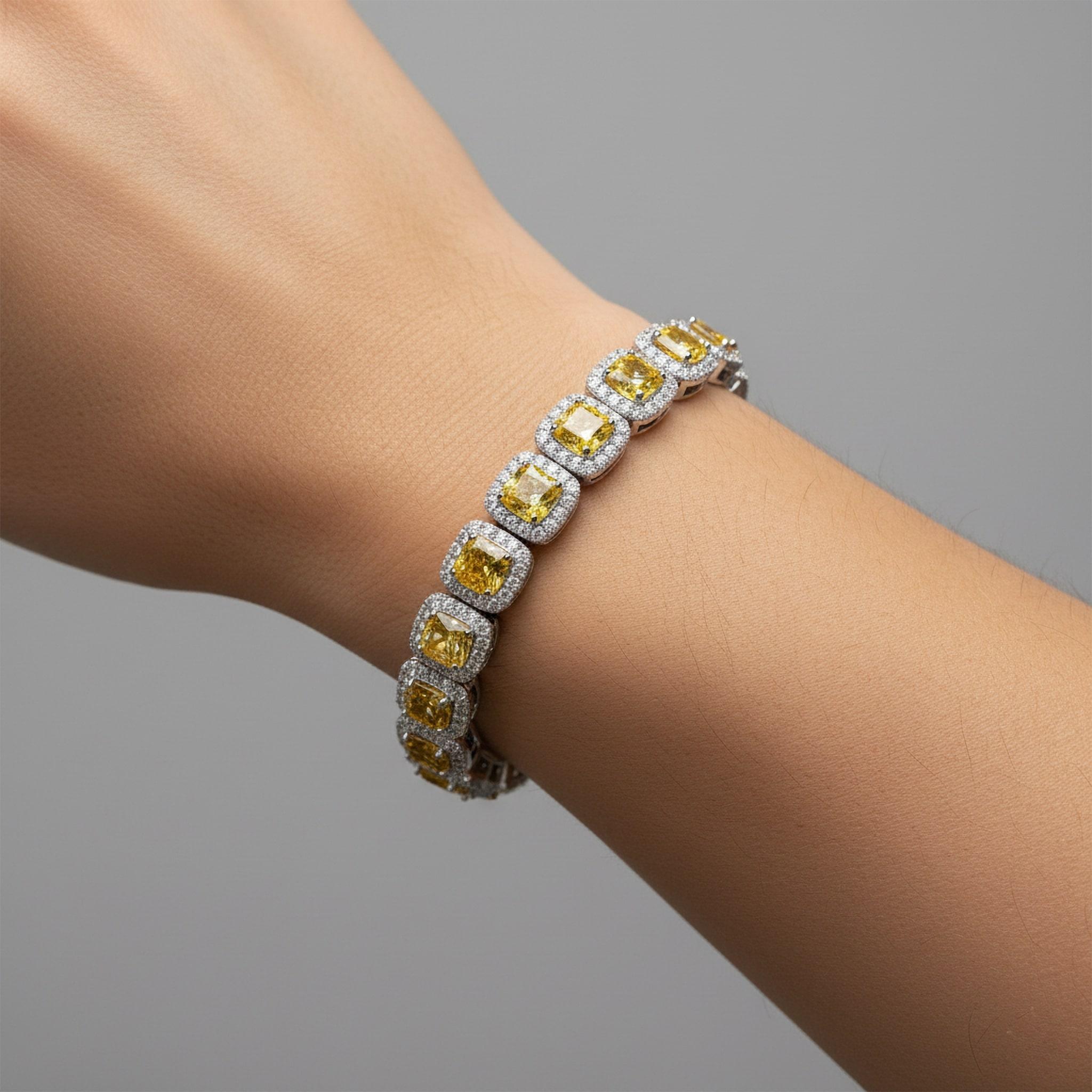 Faites une déclaration extraordinaire avec ce bracelet à double halo de diamants taillés en coussin, réalisé en riche or jaune 18 carats. Chaque pierre centrale jaune de taille coussin est élégamment encadrée par un double halo de diamants blancs