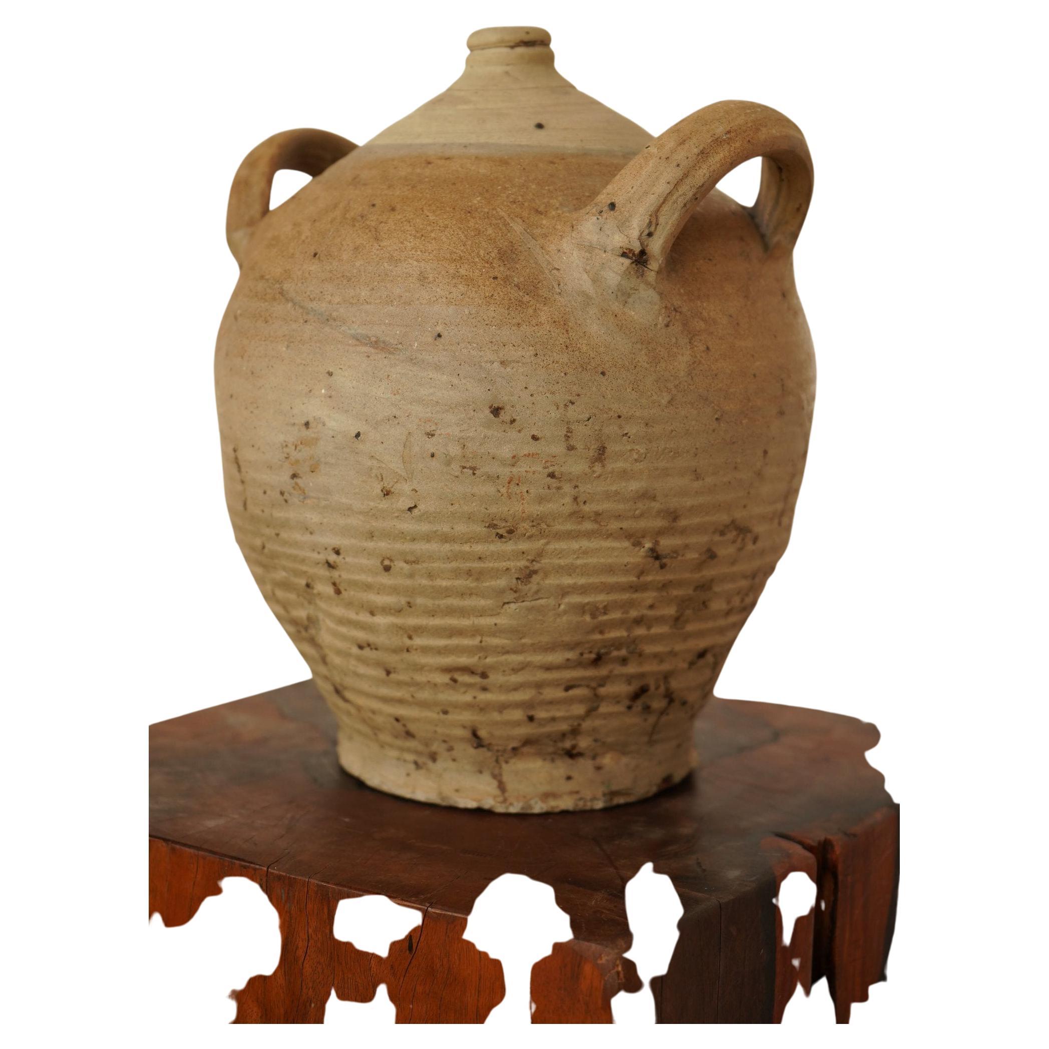 This double handled earthenware jug of pottery has a narrow mouth and two handles.