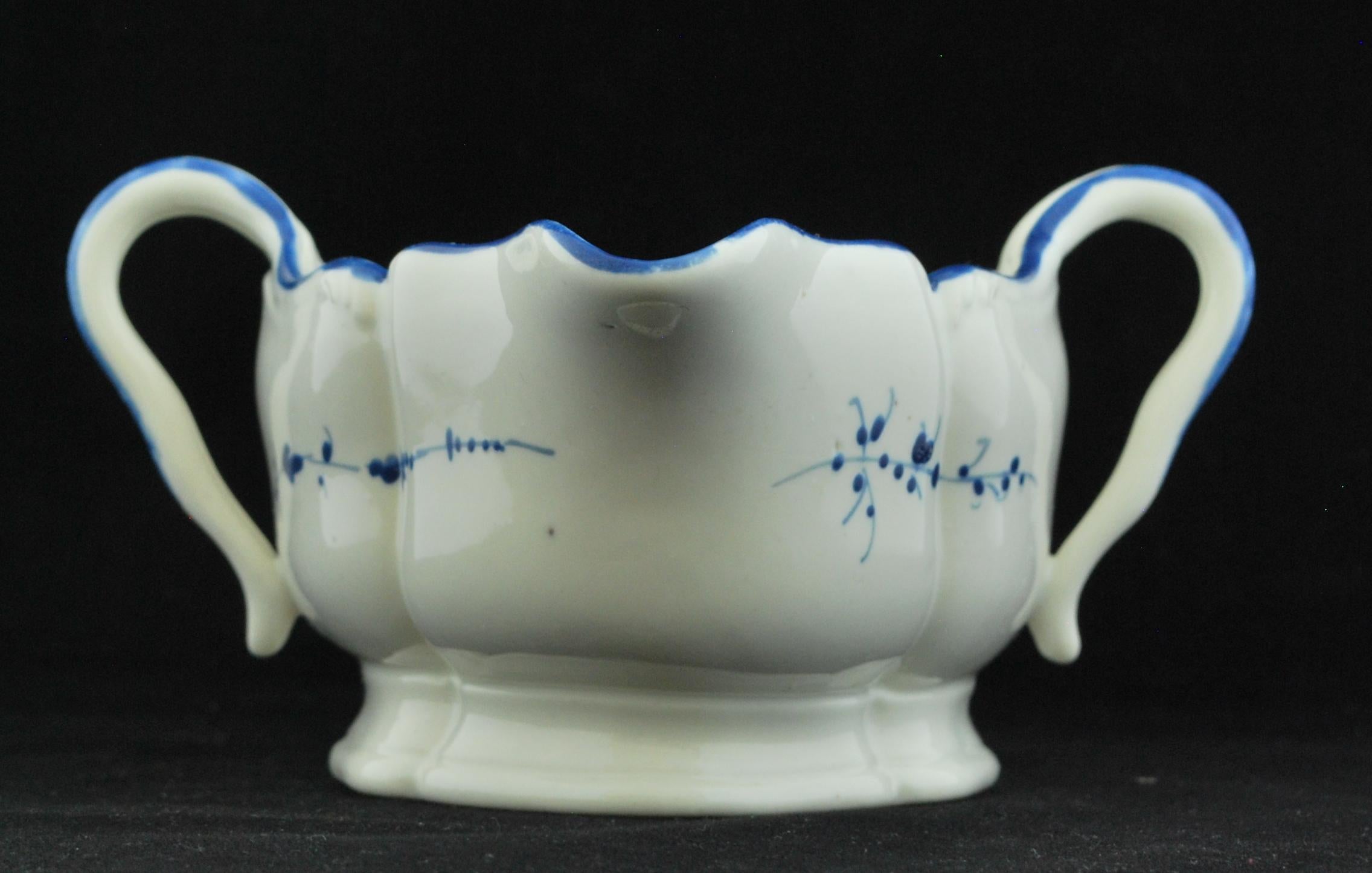 A double-handled sauce boat, with simple cobalt decoration.