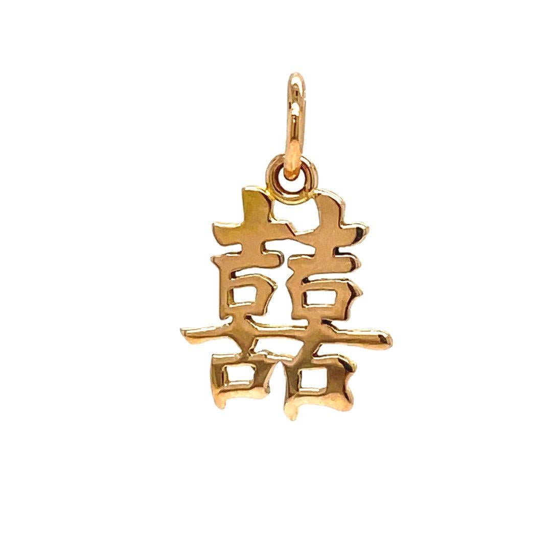 Side by side, delicately etched in 14K yellow gold, are two tokens of the Chinese character for 