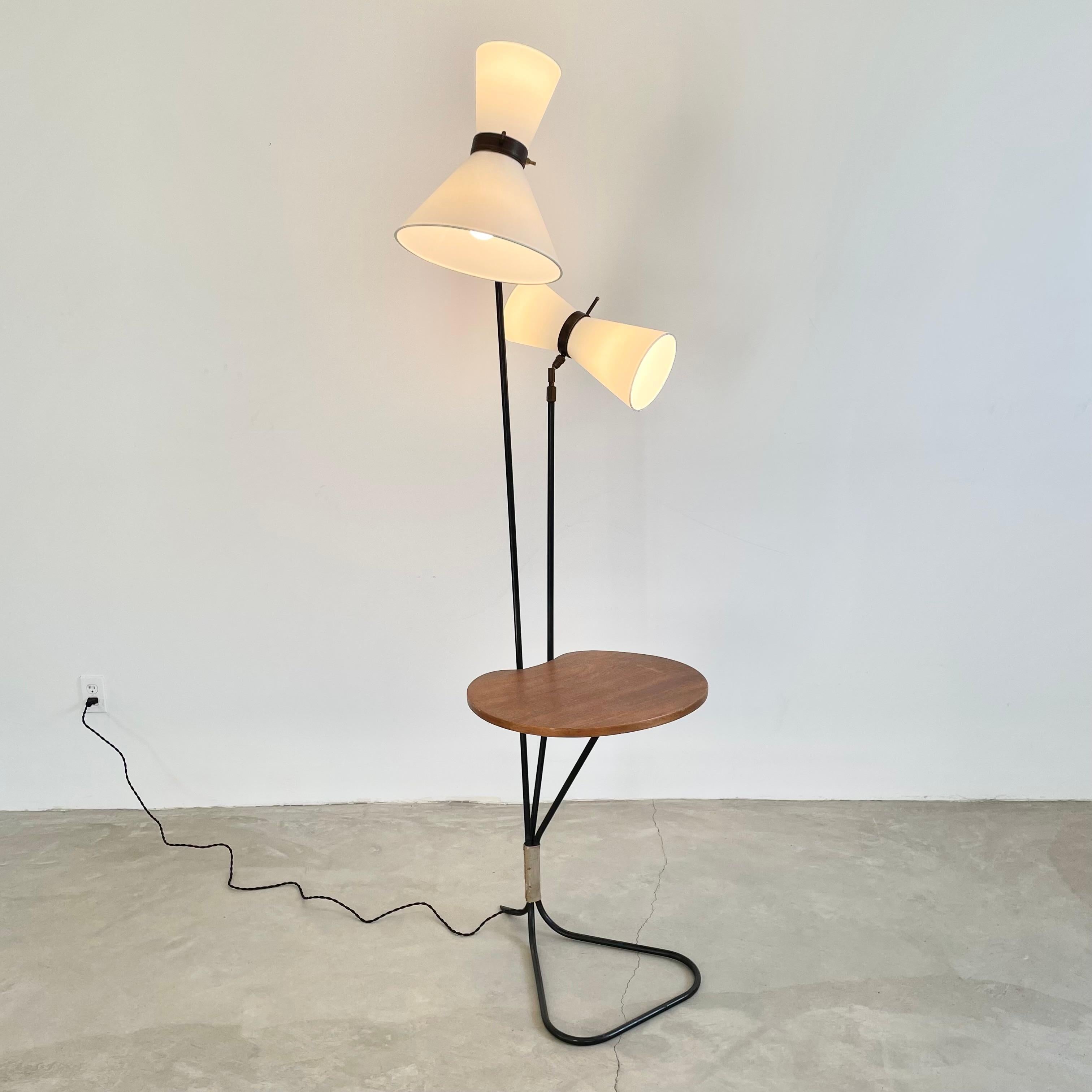 Sculptural floor lamp with tubular metal frame, made in 1950s France. Built in semi-circular wood table. Two different lighting options rise up from the wood table. Each light has two sockets for a total of 4 bulbs. Uplight and downlight options on