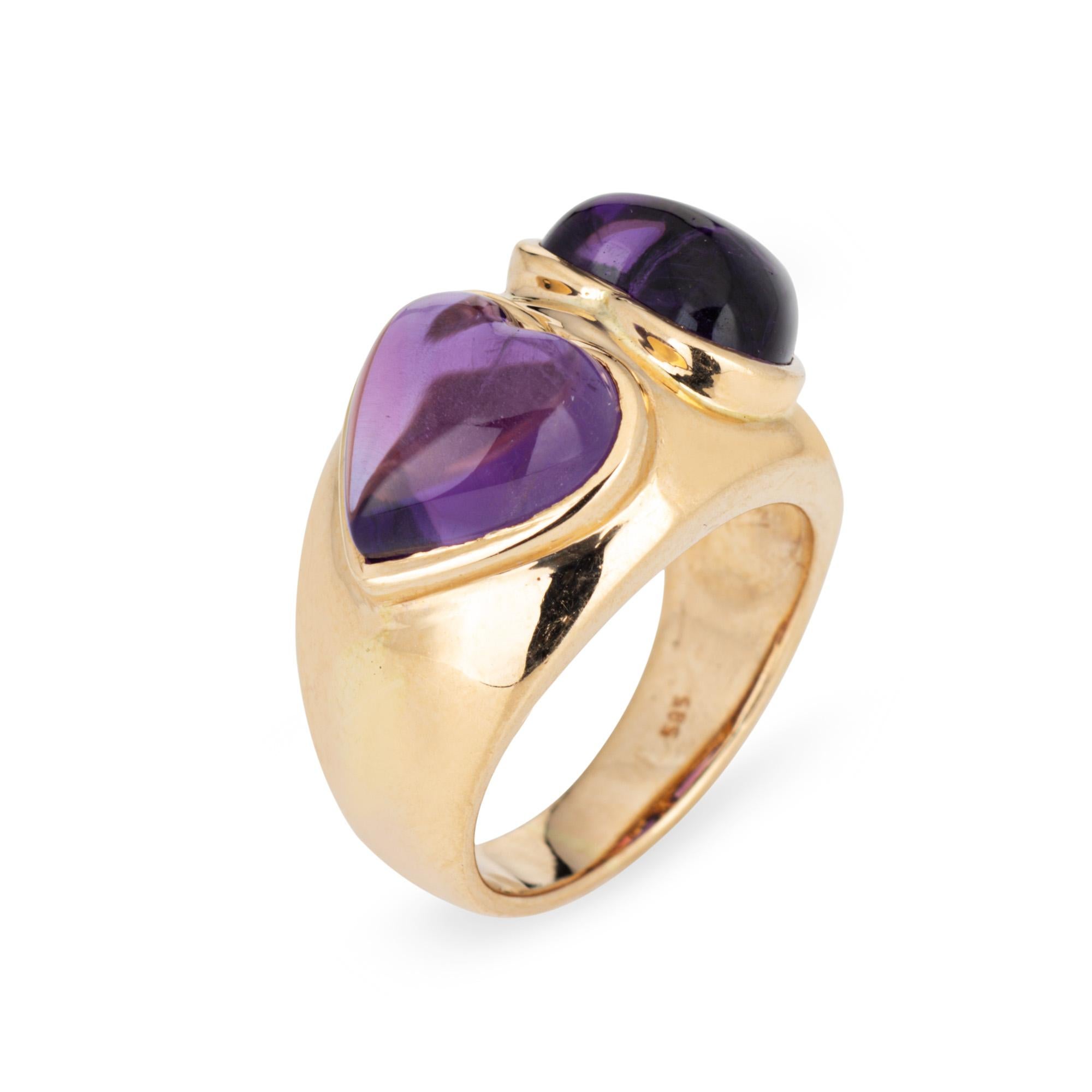 Stylish double heart amethyst ring crafted in 14 karat yellow gold (circa 1980s). 

Cabochon cut amethysts each measure 10mm. The amethysts are in very good condition and free of cracks or chips.  

The cabochon cut rich royal purple amethysts are