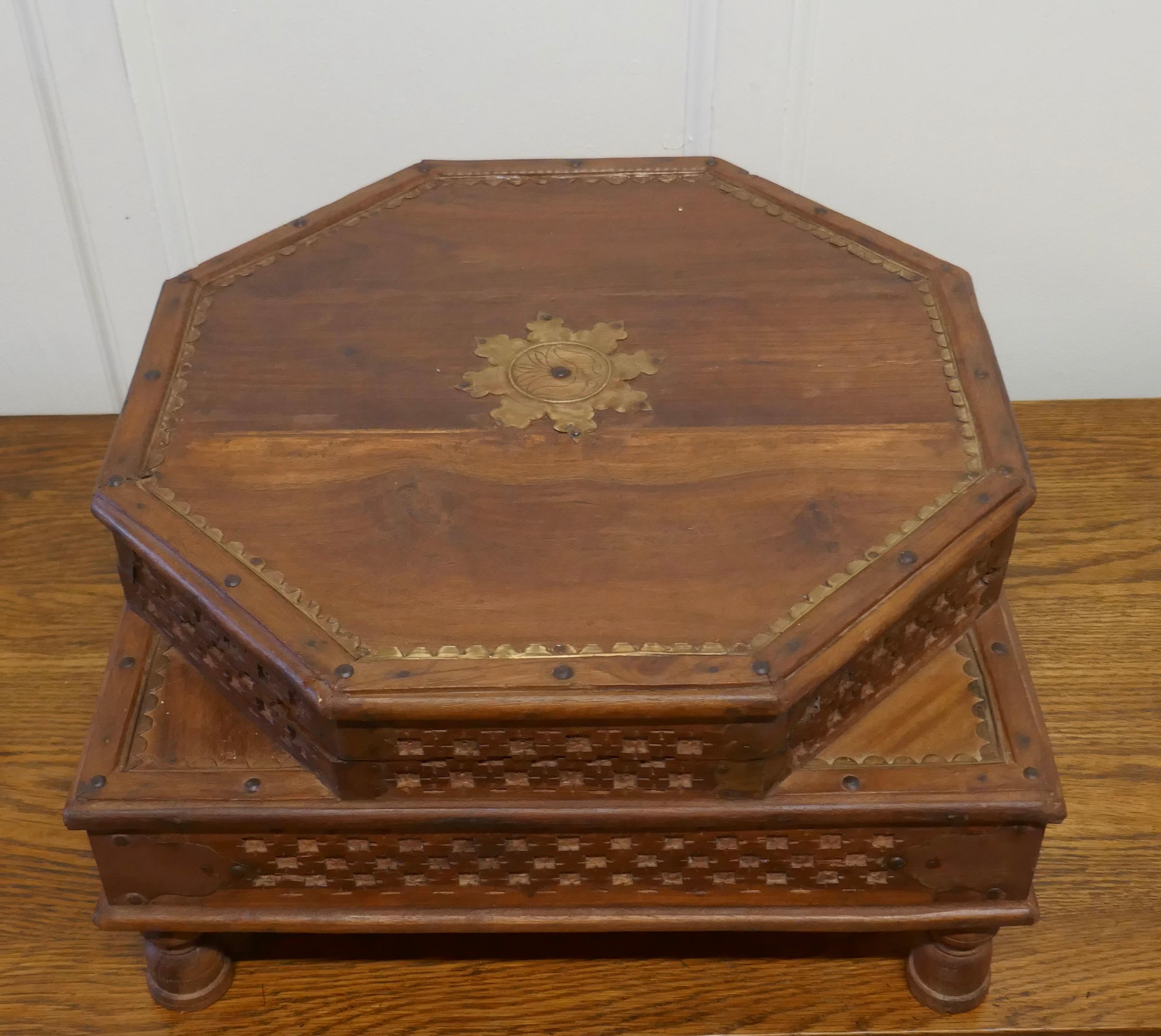 Double height carved Indian box

An unusual piece with 2 levels, the top of the box in the octagonal shape has an opening lid. The lower is rectangular and it stands on small feet
The box is carved and decorated with brass inlay 
The box is 10”