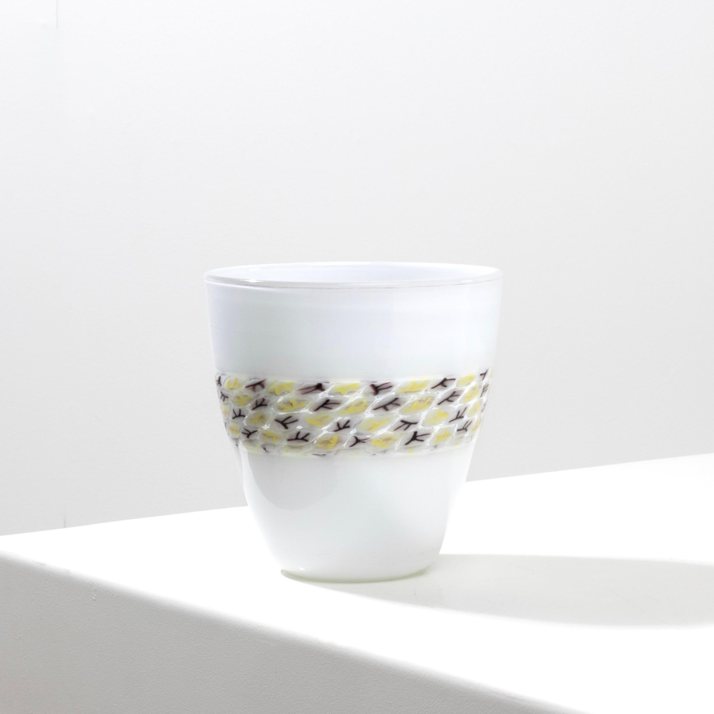 Vaso doppio incalmo in vetro lattimo (vetro bianco).
Fascia centrale in vetro trasparente decorata con murrine con decorazioni gialle e melanzane.