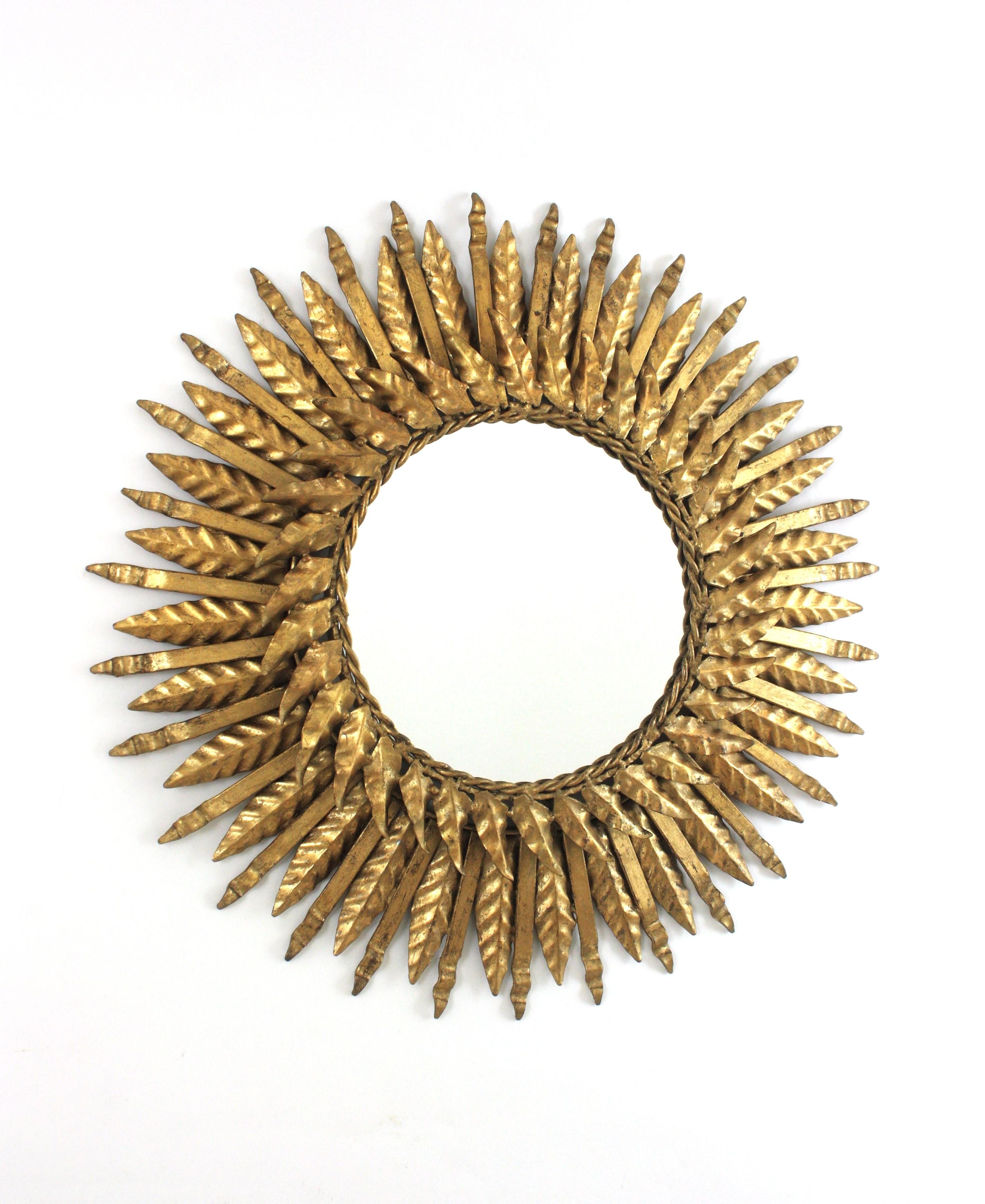Espejo Español Único, Hierro Dorado, Pan de Oro
Espejo de sol de doble capa, España, años 50
Este llamativo espejo de sol tiene un marco con dos capas. Una capa de hojas más grandes y rayos puntiagudos. Una capa más pequeña de hojas rodea el vaso,