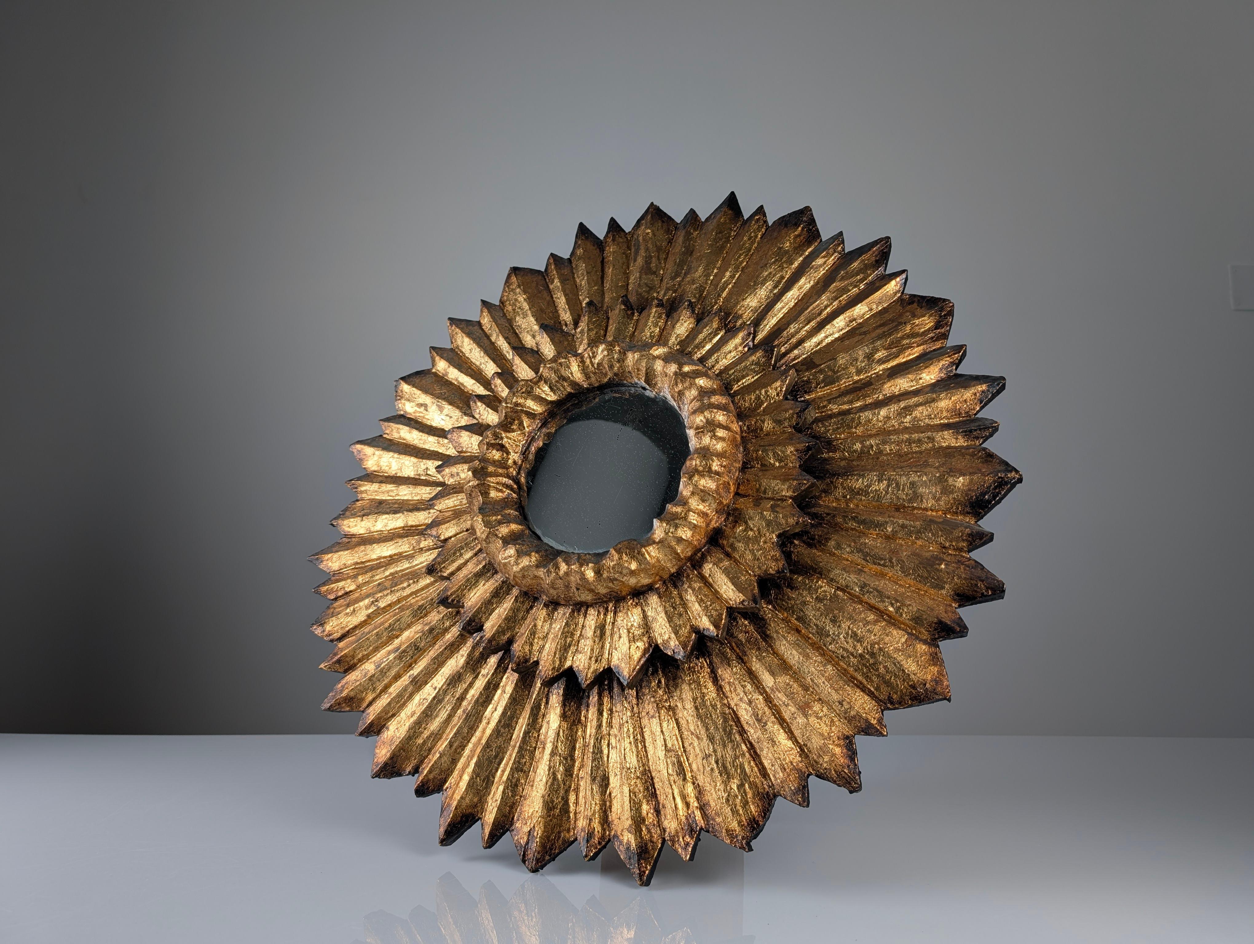 Dieser atemberaubende Spiegel mit doppeltem Sonnenschliff kombiniert traditionelle spanische Handwerkskunst mit einem Design, das an die Grandeur vergangener Epochen erinnert. Seine Struktur ist sorgfältig aus Holz geschnitzt und mit Blattgold