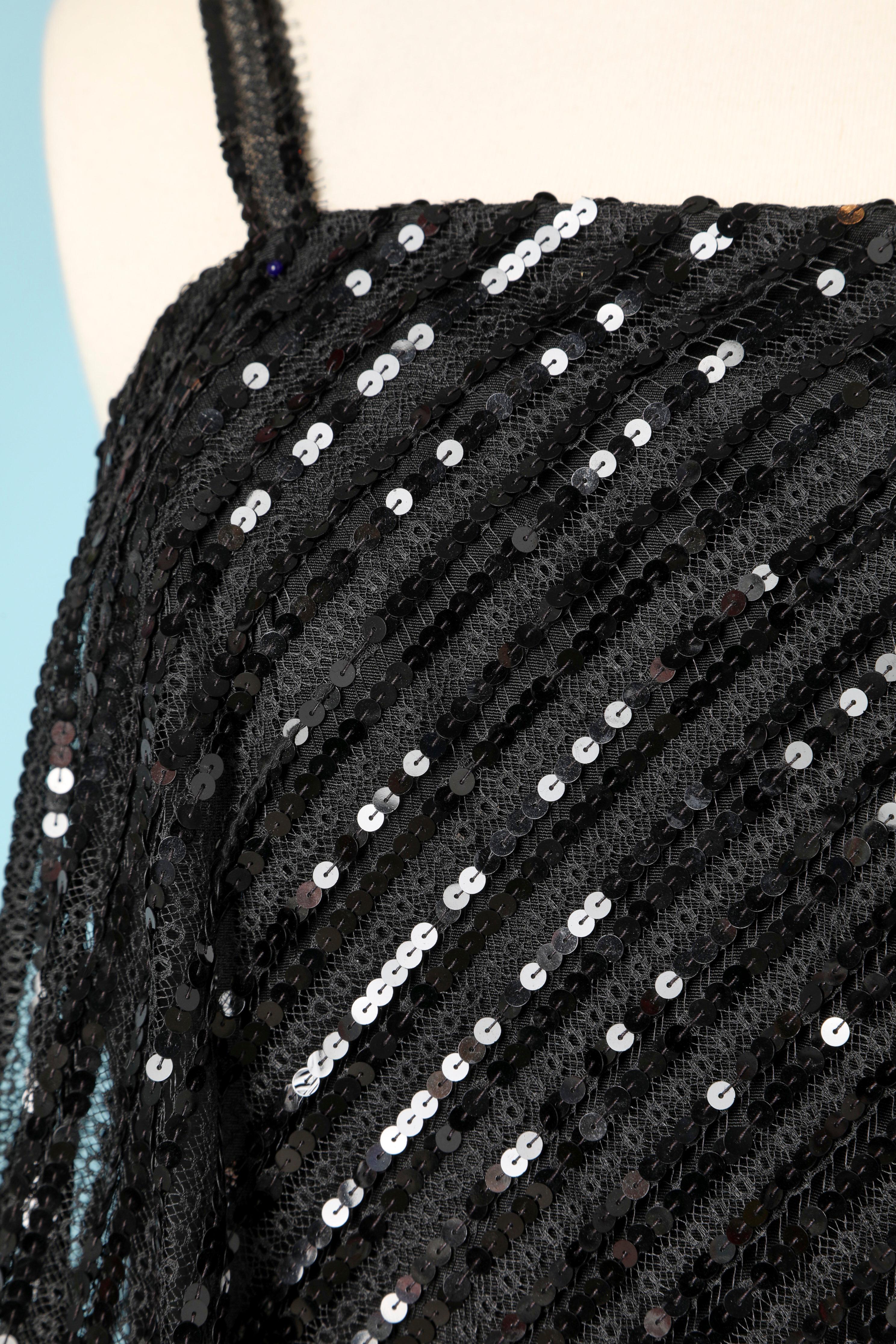 Vestido de doble capa con la capa superior de lentejuelas negras. No hay etiqueta de composición del tejido, pero el vestido interior es probablemente de rayón y el vestido superior de encaje rígido con lentejuelas negras. El vestido interior es