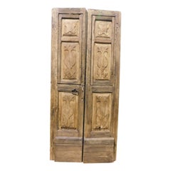 Double-leaf door in chestnut wood with carved panels, Italy
