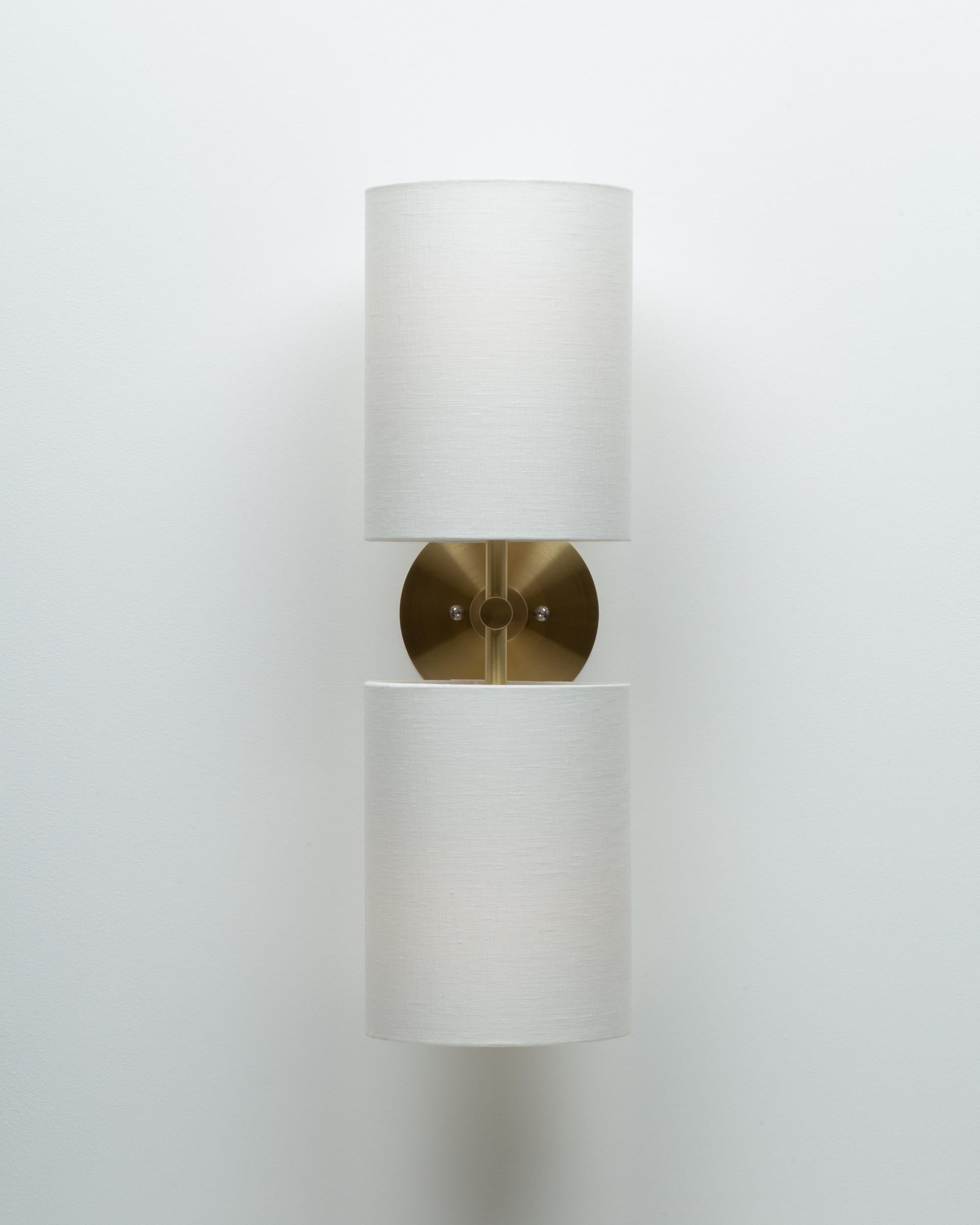 Double Linen Shade Wall Light 
Brushed Brass wall plate
2000K - 2800K  95CRI
1200 Dim to Warm Lumens 
Hard Wired
Sphere III Bulbs Included
Custom Linen Shade Colours available on request. 
Handmade in Hackney Wick, London.