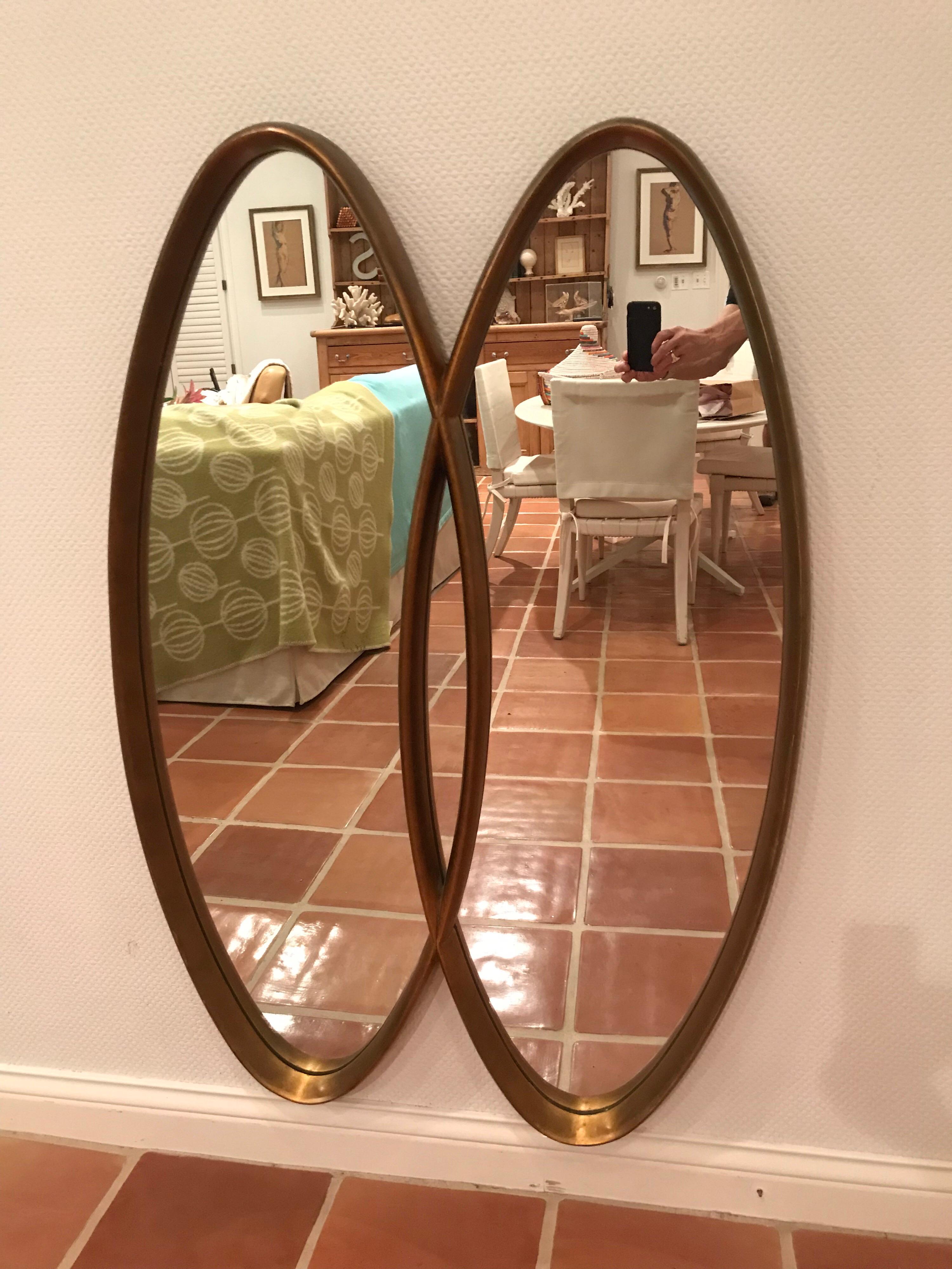 This is a vintage giltwood double oval intersecting mirror from the 1950s.