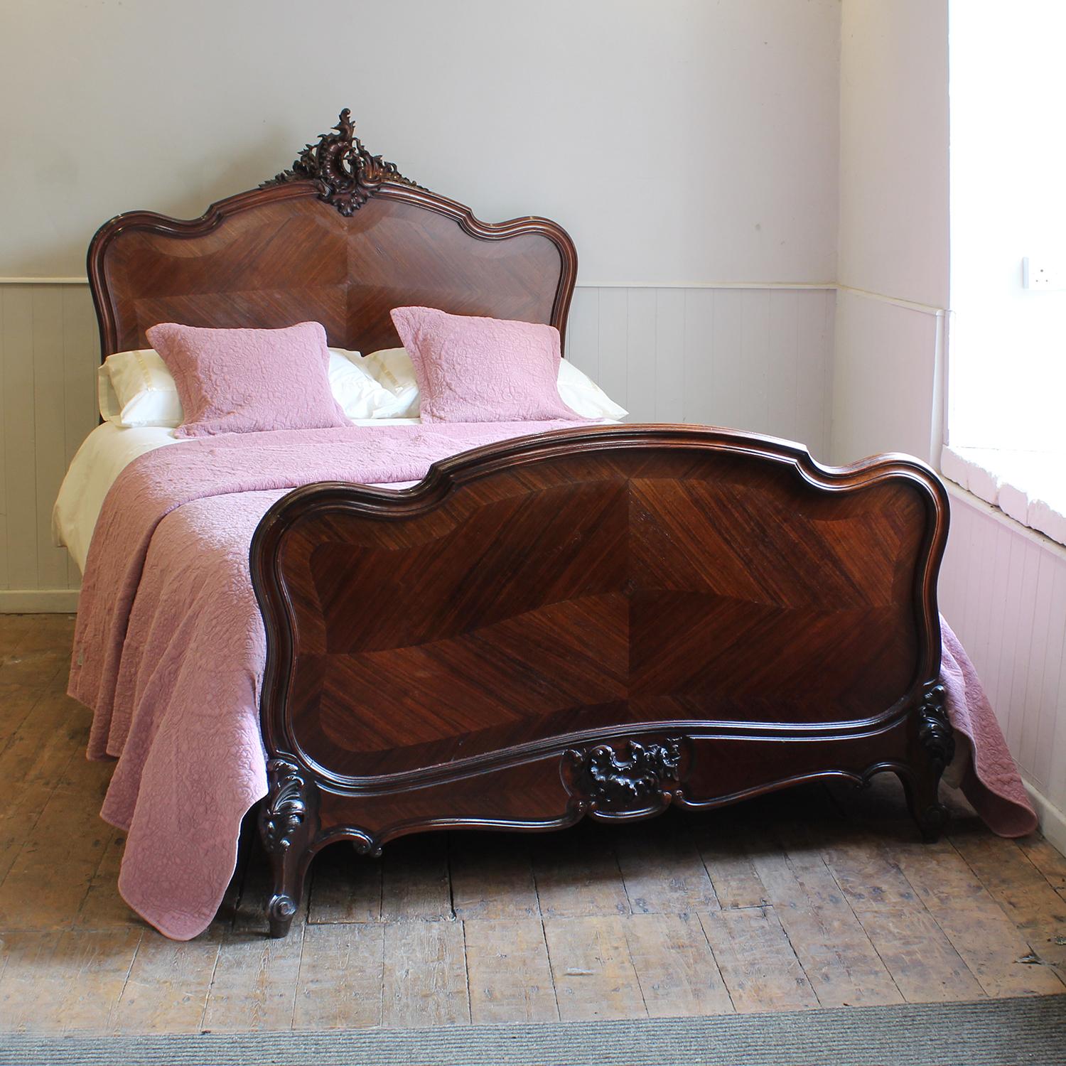 A fine French Louis XV style bed from the late Nineteenth Century with carved pediment, quartered veneered panels and elegant shaping.

This bed accepts a double 54