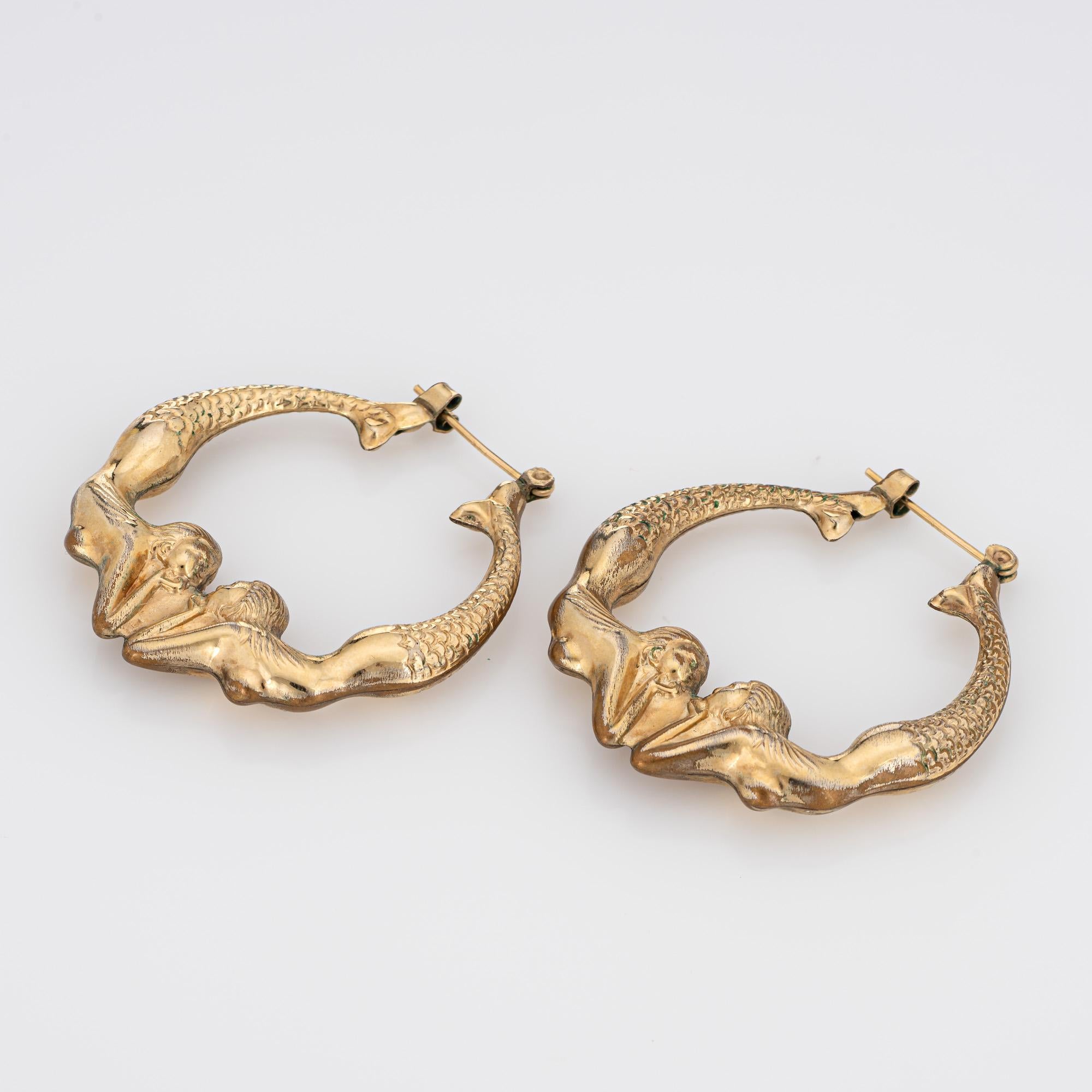 Finely detailed pair of vintage double mermaid earrings crafted in 14k yellow gold (circa 1980s).

The stylish earrings feature two mermaids joined together at the base of the earrings, with textured scale like detailing to the tail, flowing hair