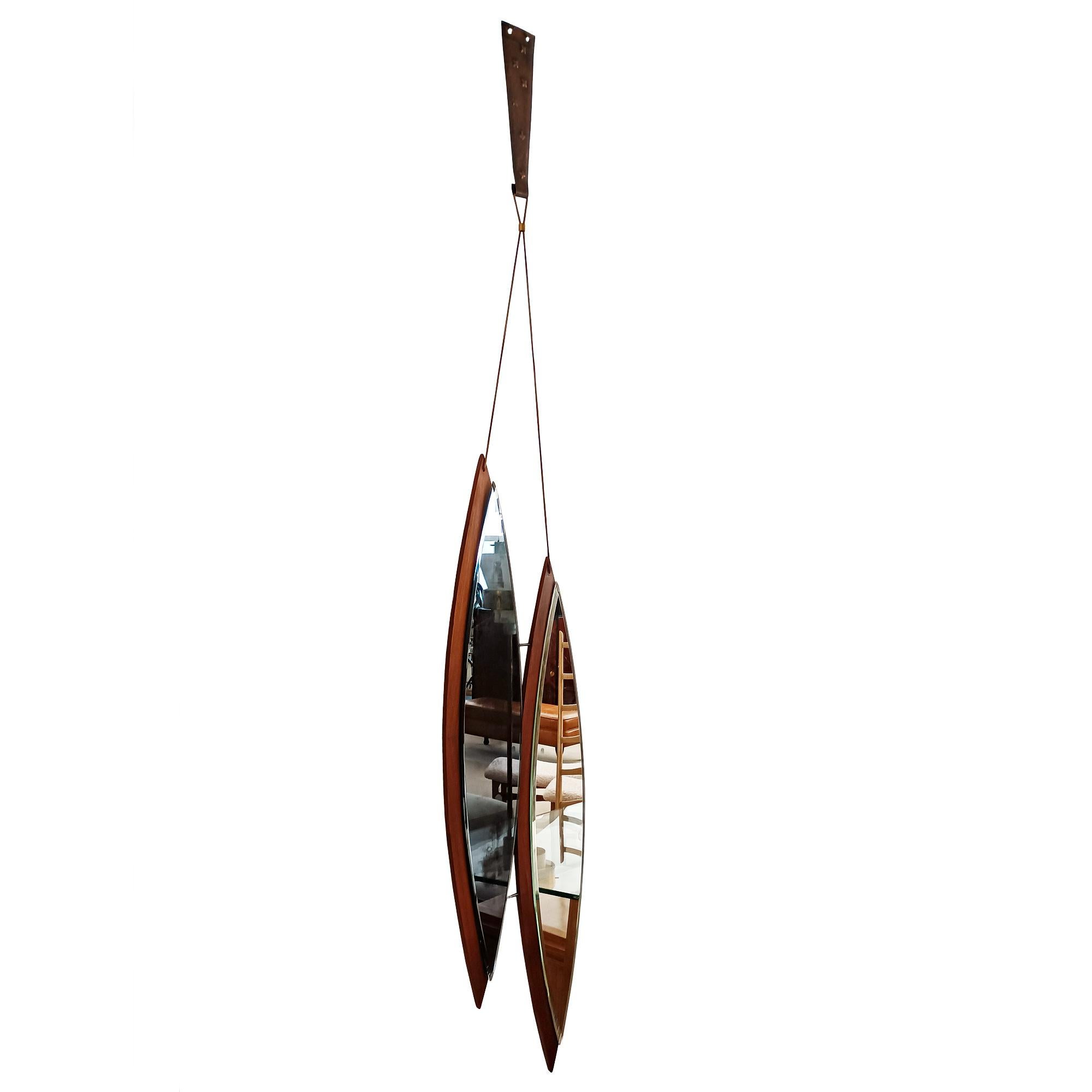 Double miroir monté sur palissandre, l'un en verre blanc, l'autre en verre bleu oxydé, biseauté sur le côté gauche, système de fixation en laiton et cordons en cuir.

Italie vers 1960