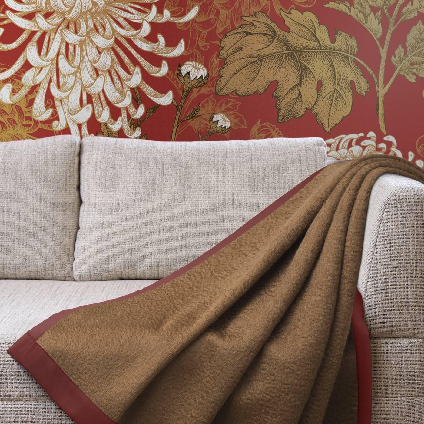 Luxuriously soft, this blanket blends the warmth of 10% virgin wool with the softness of 80% mohair, framed by a contrasting silk border for a richly-tailored finish. This generously sized blanket features an elegant brown and red color combination
