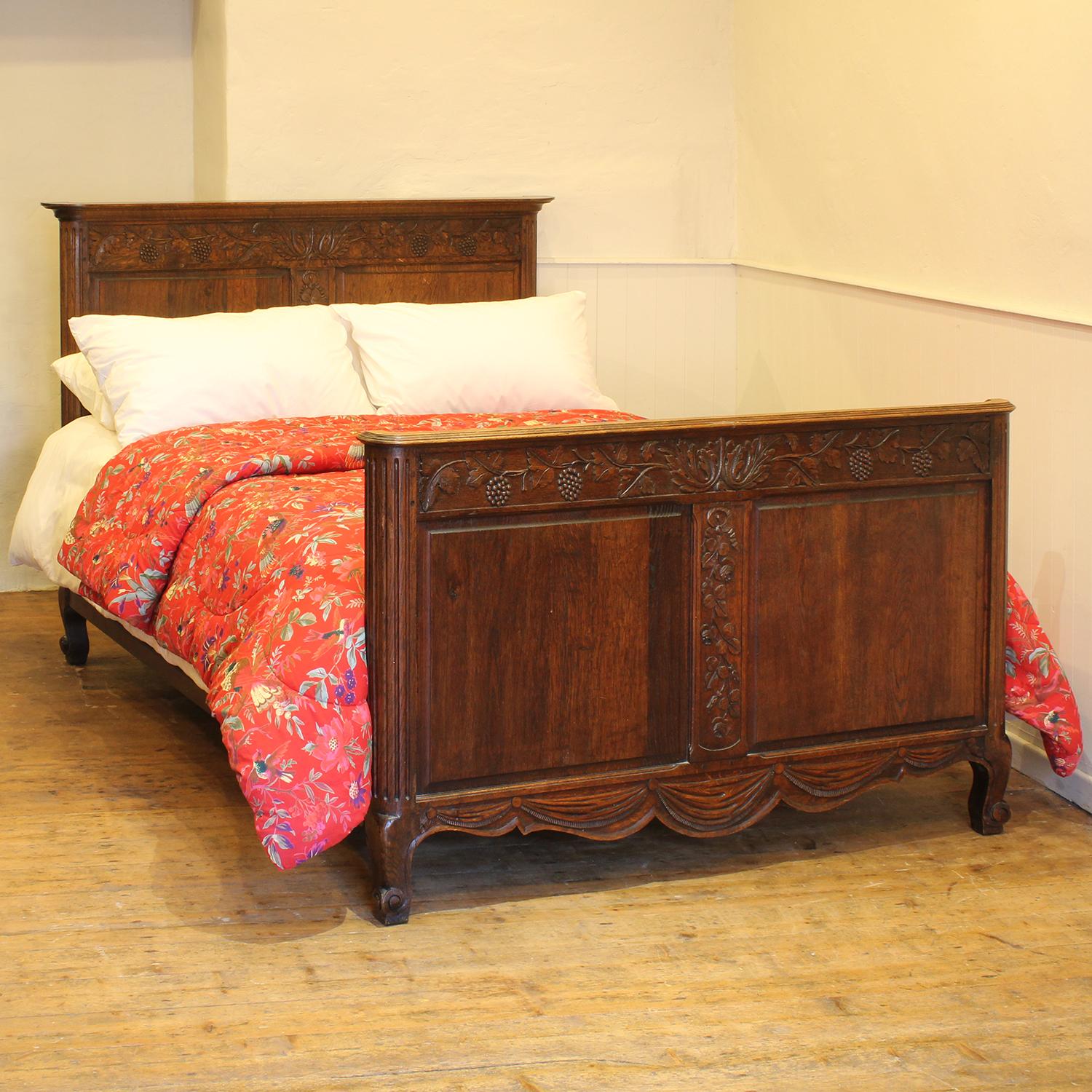 A country style oak bed with fine carving depicting grape vines, roses and swags.

This bed accepts a standard double, 4ft 6in (54 in), base and mattress set.

The price is for the bed frame with a firm bed base to support the mattress. This can be