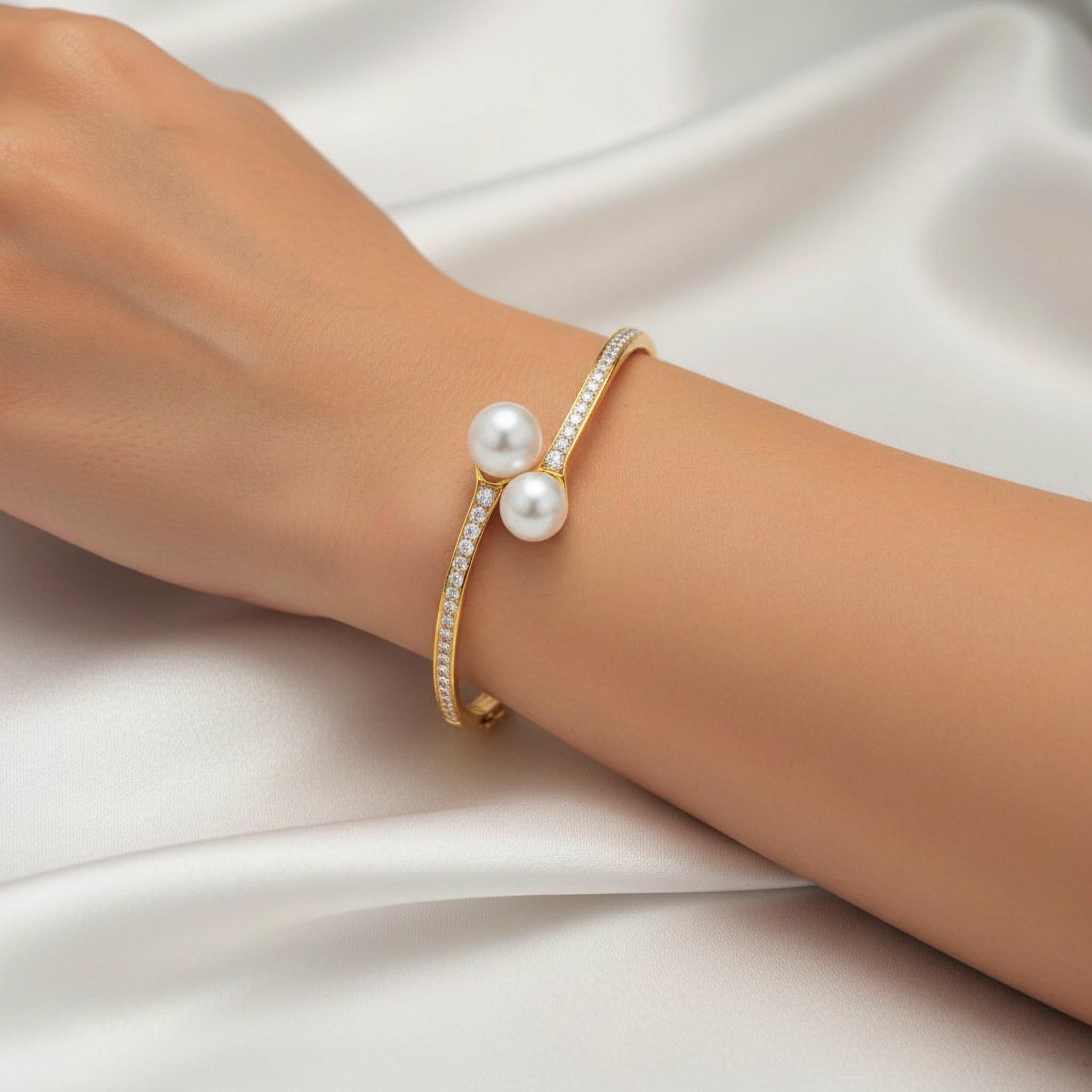 Timeless elegance meets modern sophistication in this Double Pearl and Diamond Open Bangle Bracelet, beautifully crafted in 14K Yellow Gold (available in 18K upon request). Two luminous white pearls rest gracefully on each end of the open bangle,