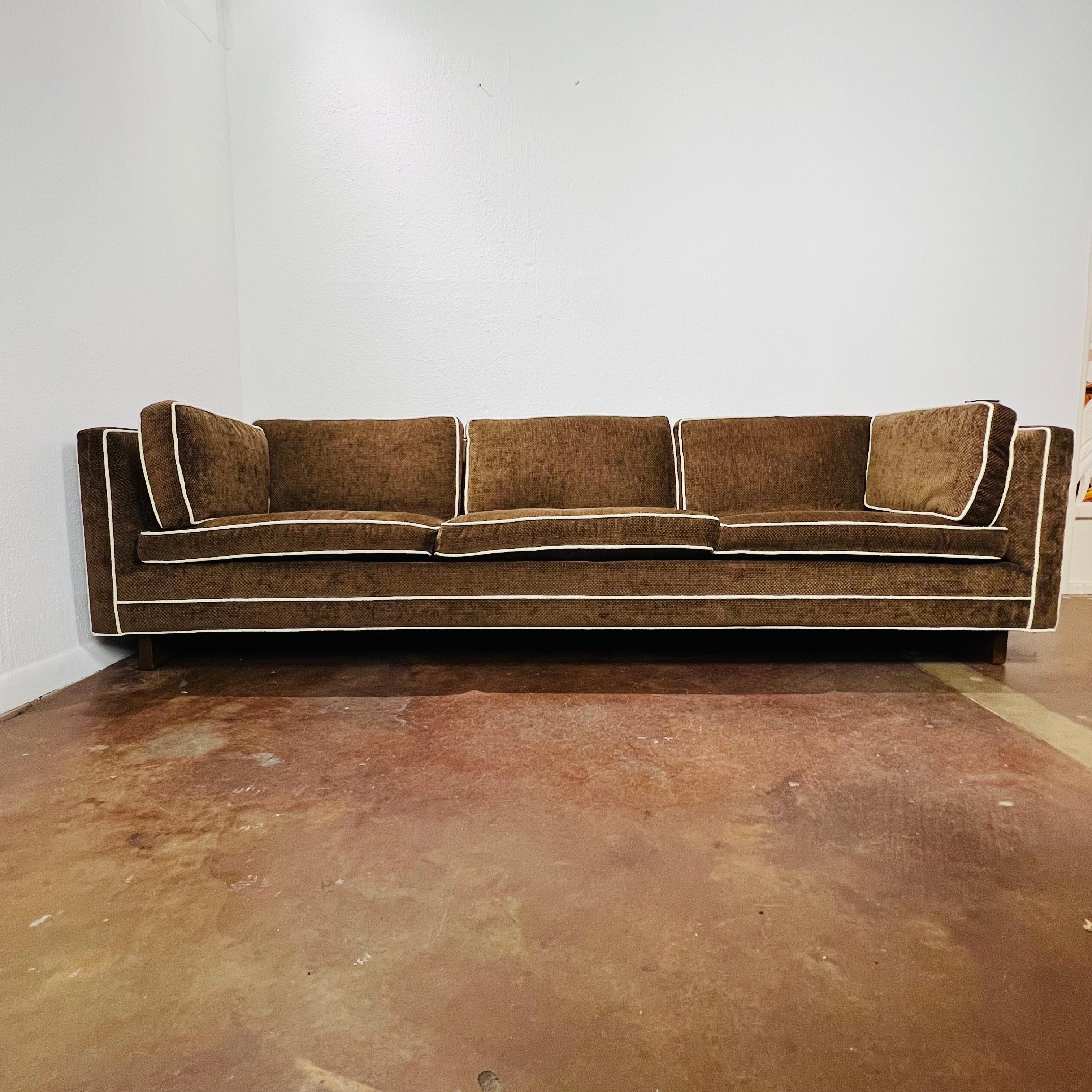 Vintage tuxedo sofa on double pedestal base. Loose seat and back cushions, straight arms and back, and deep comfortable seats. Original brown velvet upholstery; shows normal wear from age and use. Wood pedestal bases have some chips/dings/scratches.