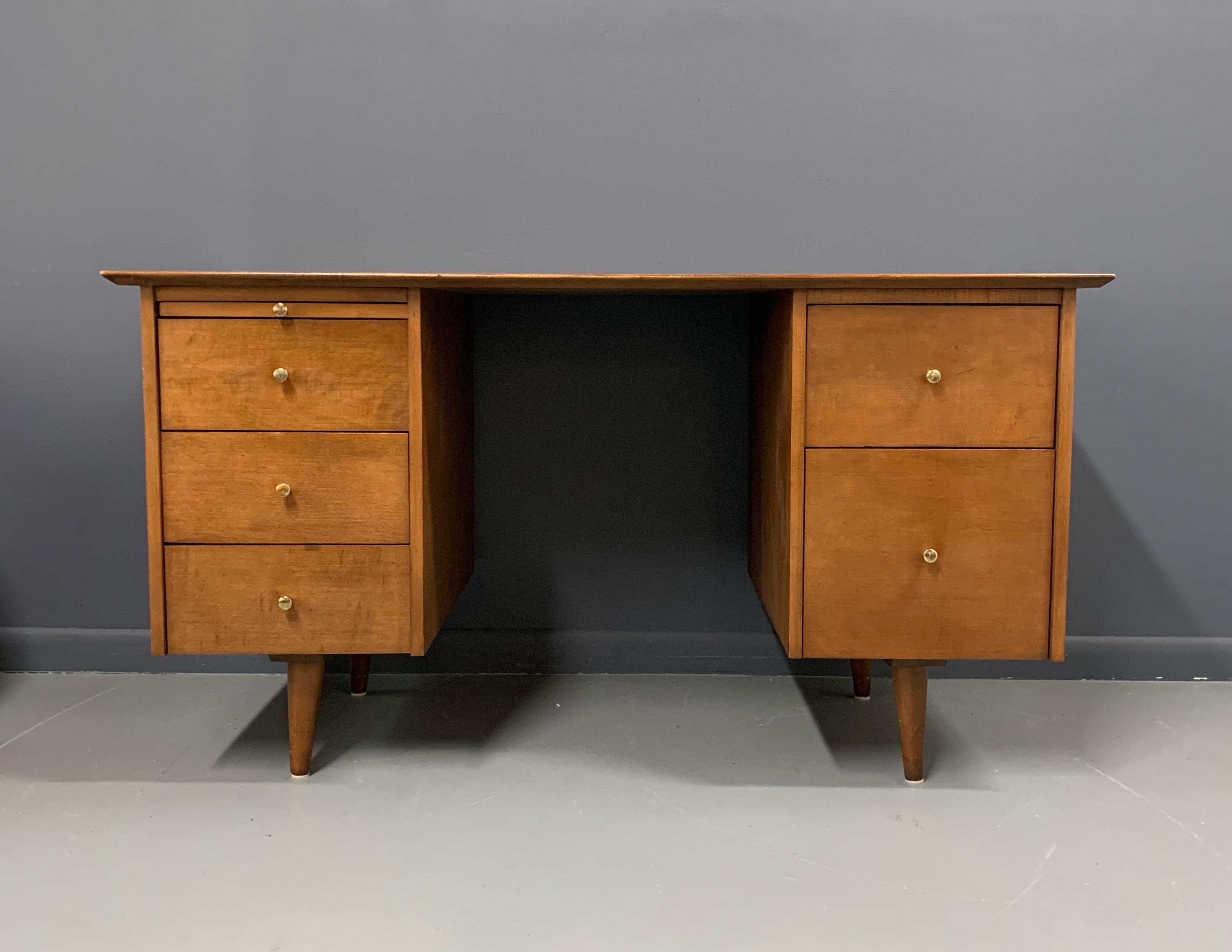 A fine example of a double pedestal desk with vintage finish and solid brass hardware. By Paul McCobb for the Planner Group line from Winchendon. American, circa 1950.