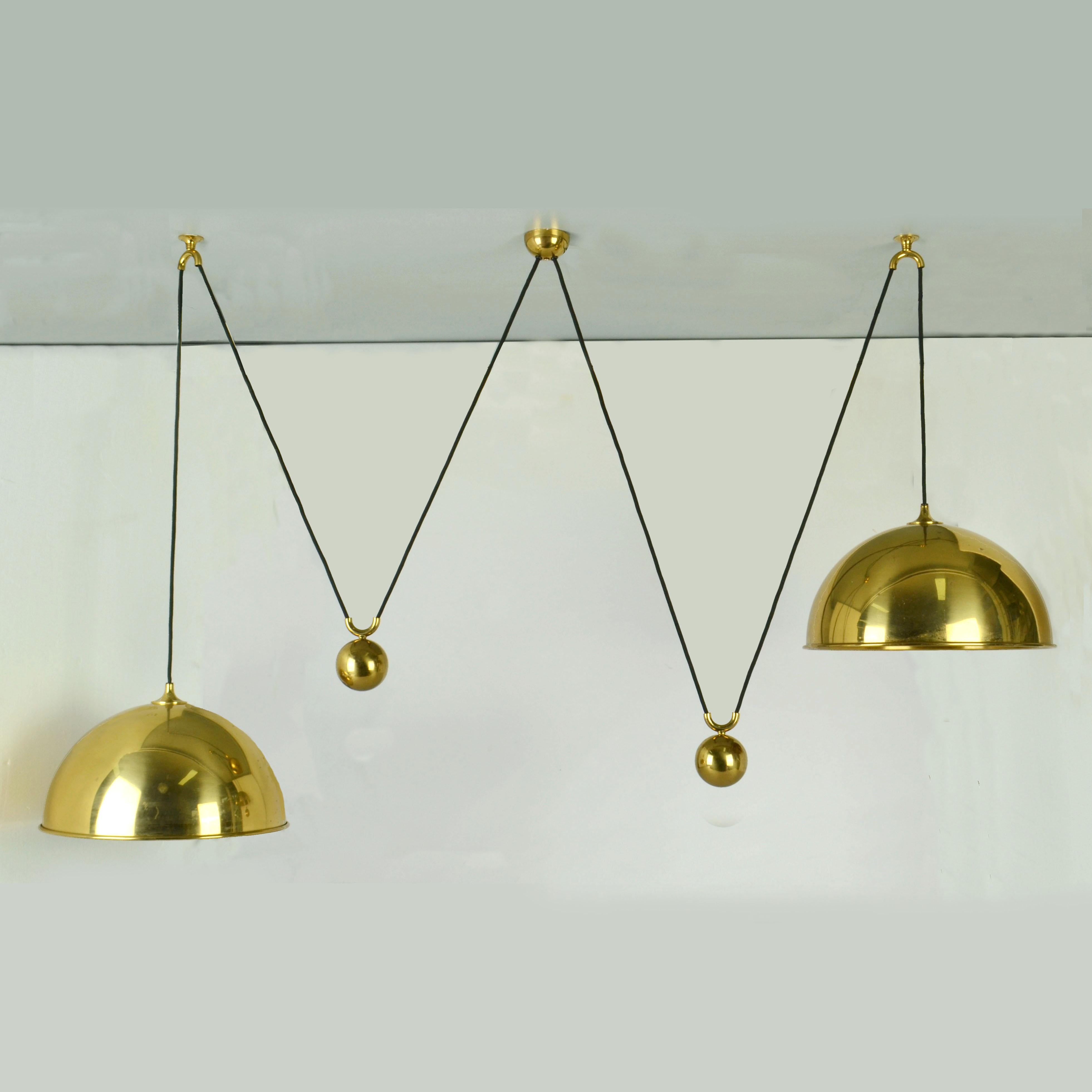 Pendant double 'Posa' by Florian Schulz, 1970's. Two brass pendants suspended, each with their own brass ball counter balance pulley system connected to side weight.s. Elegant and minimal pendants in a high quality brass moves smoothly up and down