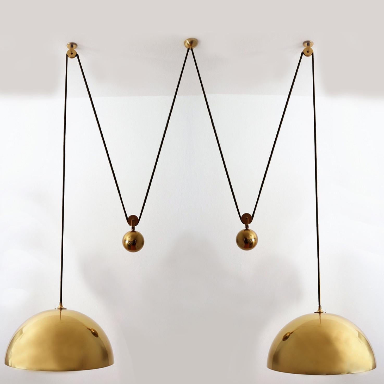 Fantastic Double Pull pendant light by Florian Schulz, Germany, Europe. Design period: 1970-1979, production period: 2022.

Two brass polished unlacquered pendants suspended with their own brass ball counter balance. One canopy supports both