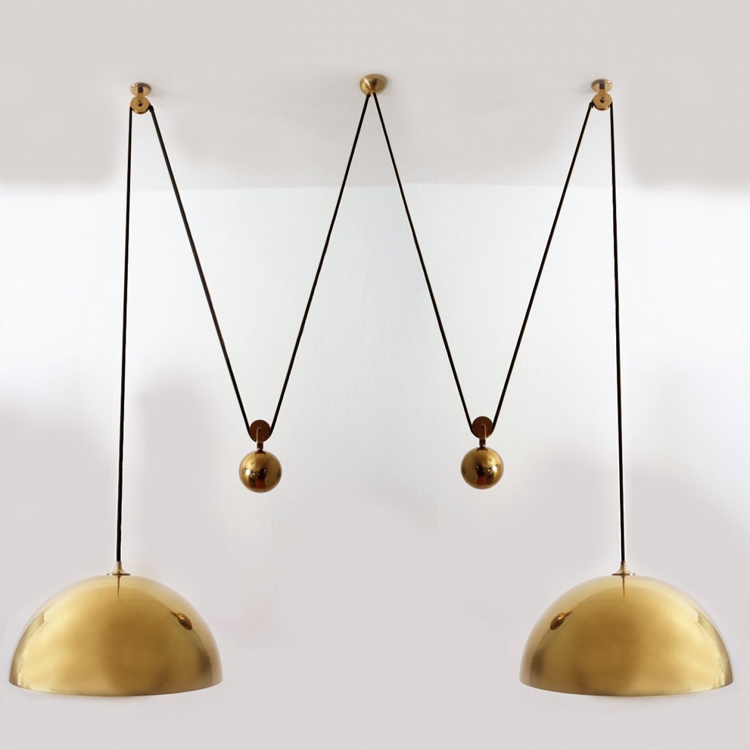 Fantastic Double Pull pendant light by Florian Schulz, Germany, Europe. Design period: 1970-1979, production period: 2022.

Two brass polished unlacquered pendants suspended with their own brass ball counter balance. One canopy supports both