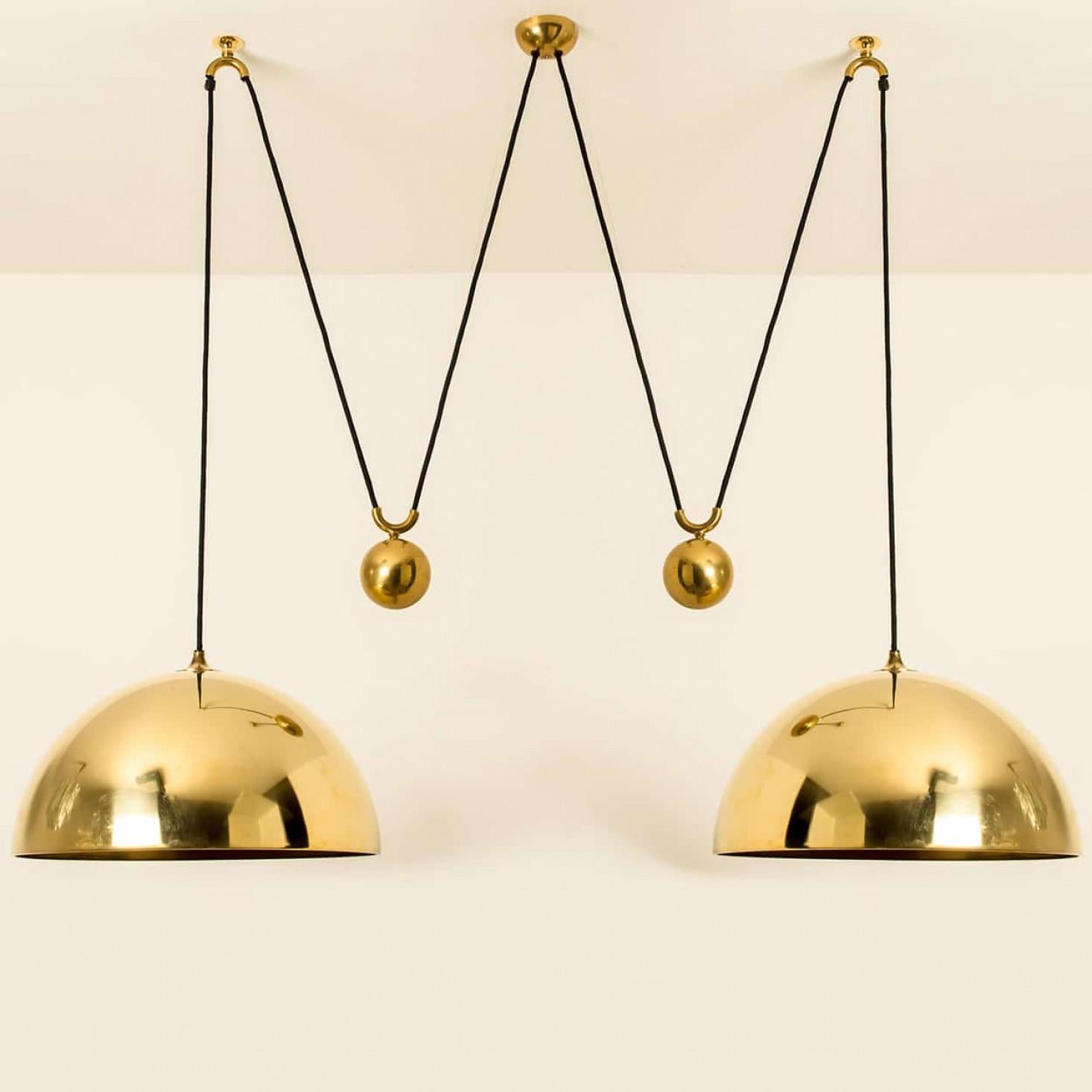 Fantastic Double Pull pendant light by Florian Schulz, Germany, Europe. Design period: 1970-1979, production period: 2022.

Two brass polished unlacquered pendants ( D 40 cm) suspended with their own brass ball counter balance. One canopy supports