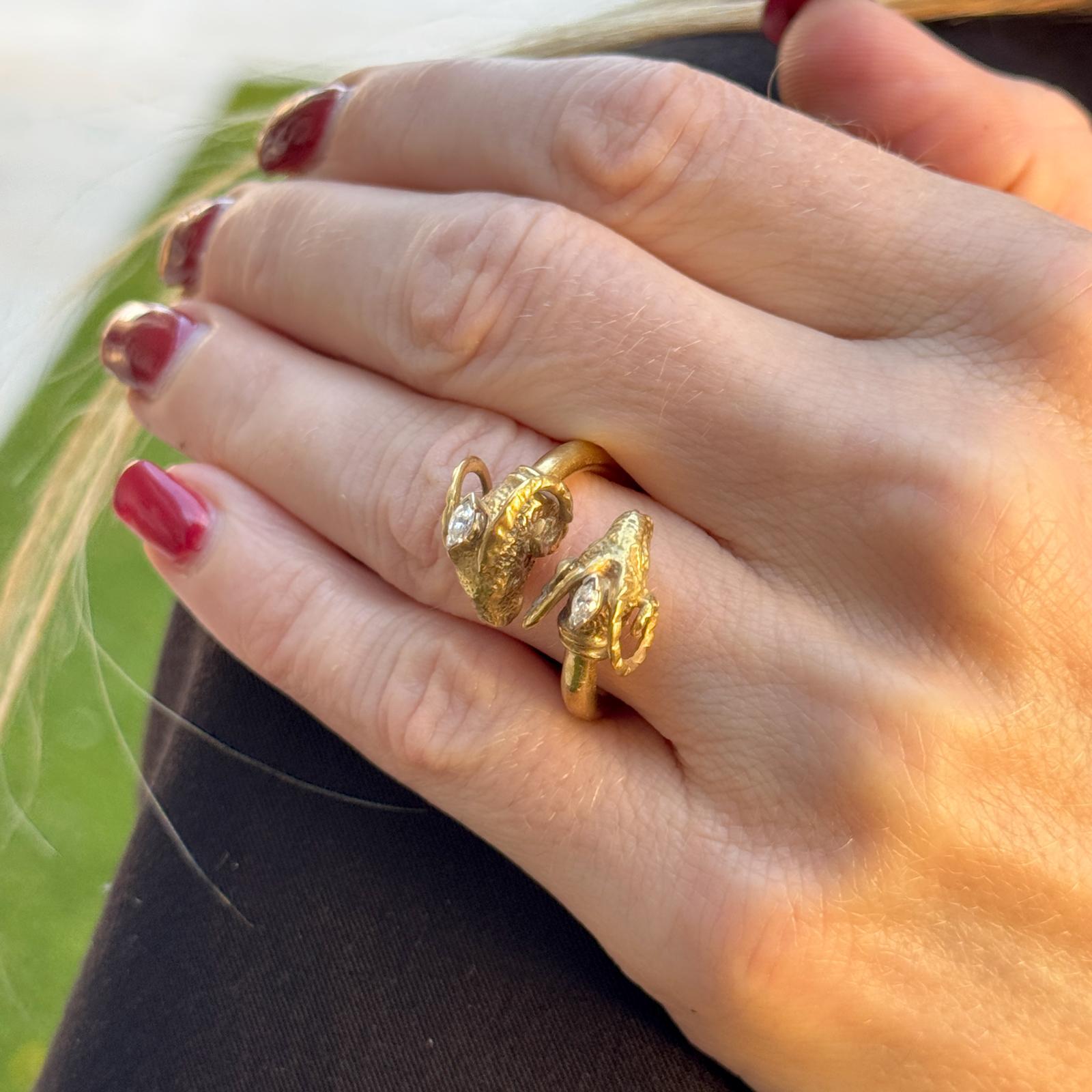 This vintage 18k yellow gold double ram's head bypass ring is a striking statement piece, rich in character and craftsmanship. Featuring two intricately detailed ram’s heads facing each other, the design symbolizes strength and determination. Two