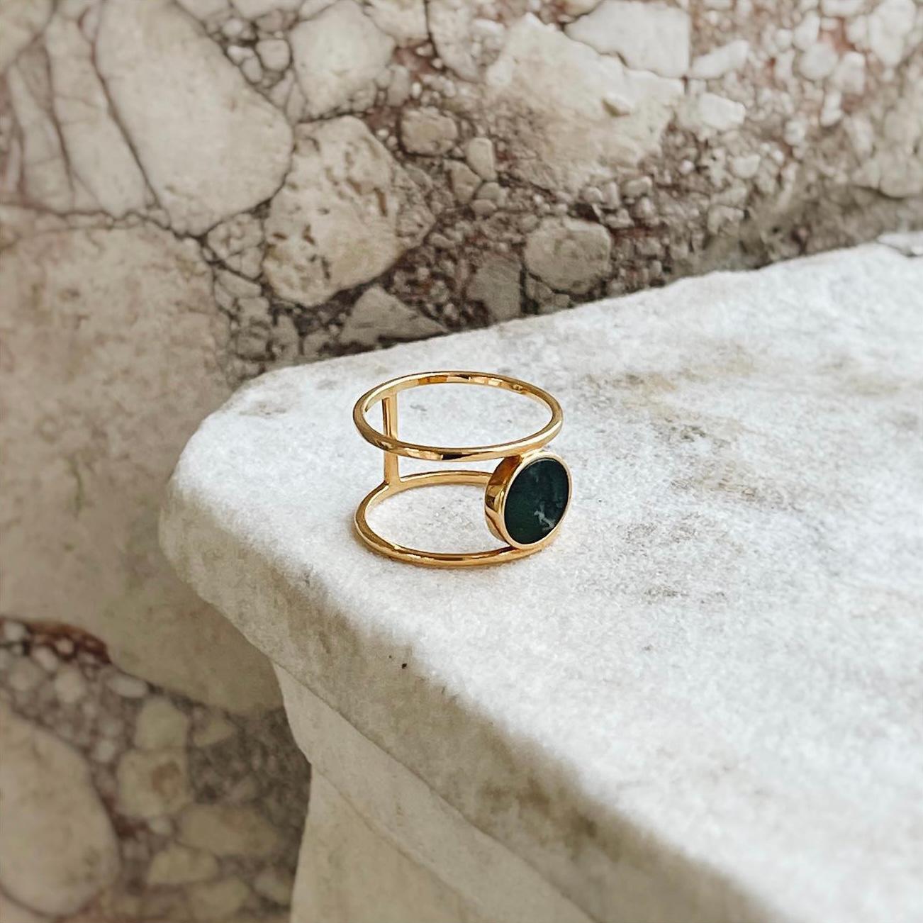 Discover our captivating bestseller ring adorned with a stunning green stone that is sure to capture your heart. Its unique design, featuring double rings, effortlessly blends simplicity and modernity, allowing you to express your personal