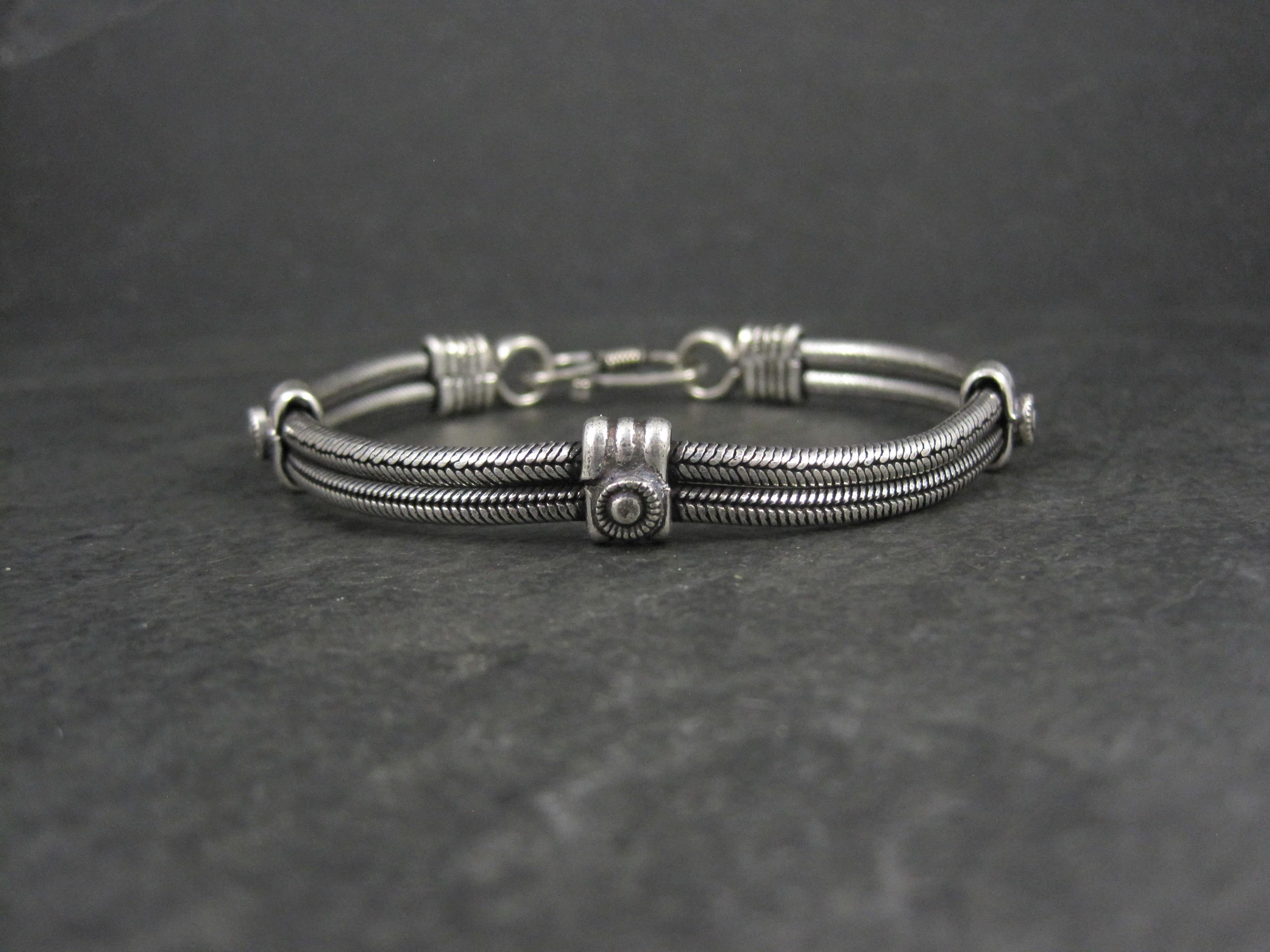Questo splendido bracciale vintage è in argento sterling.
Presenta 2 catene a serpente rotonde collegate da 3 fasce di tipo tribale.

Questo braccialetto misura 3/8 di pollice di larghezza. Misura 8 pollici da un'estremità all'altra.
Peso: 24