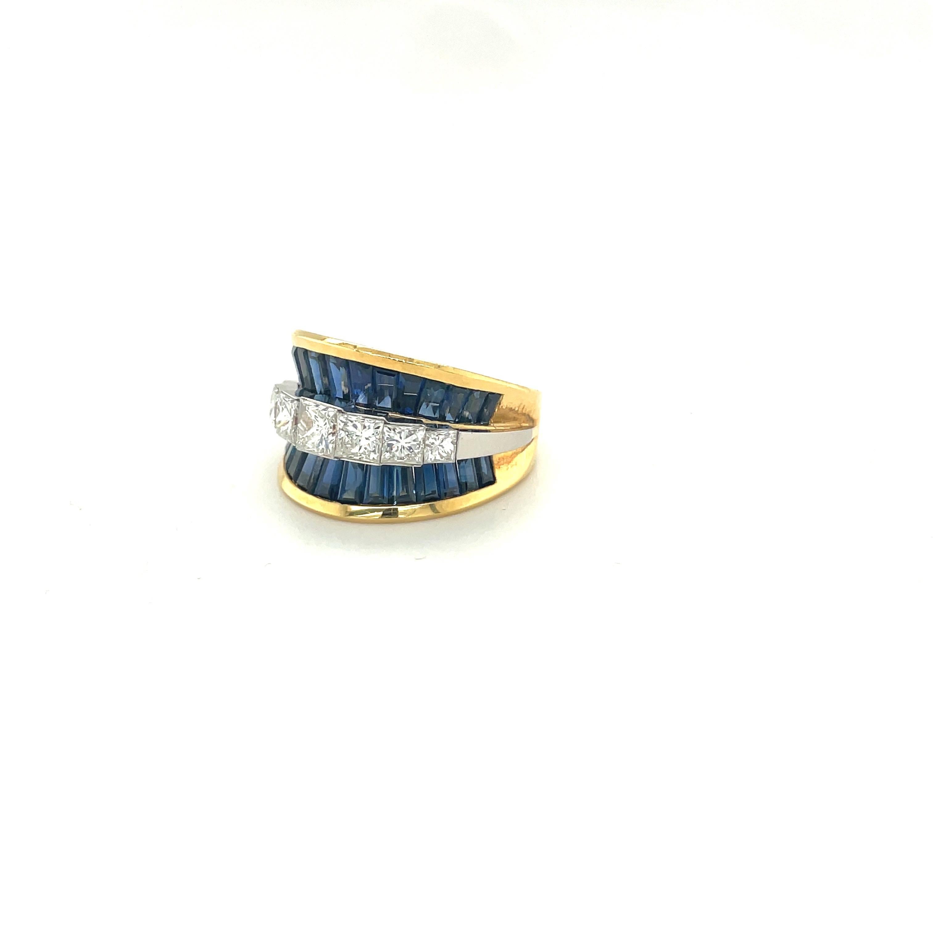 The brilliant cut princess cut diamonds are flanked by 2 rows of baguette cut sapphires, set in 18 karat gold. This concave ring has a slight taper to fit comfortably to any finger.  The combination of the princess cut diamonds and sapphire